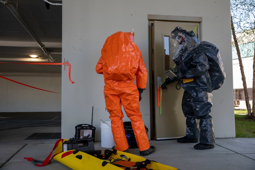 Sgt. Andrew Hunt, 103rd Civil Support Team, and Tech Sgt. Eric McComb, 103rd CST, prepares to enter a building to respond to a simulated incident at a parking garage on the University of Alaska Anchorage campus May 18 in support of Exercise ORCA 2021. ORCA is a chemical, biological, radioactive, nuclear threats response exercise designed for participants to provide support in the aftermath of hazardous materials incidents. ORCA tests interoperability between agencies, increases opportunities for working relationships, and practices requests for assistance methods. Approximately 250 National Guardsmen from CST units in Alaska, California, Connecticut, Colorado, Idaho, Ohio, Oregon, Rhode Island, South Carolina, South Dakota, Washington, and Wisconsin are in Alaska to participate in Exercise ORCA 2021. Numerous support units and civilian agencies participated in the exercise as well. (U.S. Army National Guard photo by Spc. Grace Nechanicky)