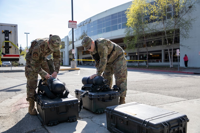 Sgt. Jason Williams, 103rd Civil Support Team, and Senior Airman Scottie Branson, 176th Civil Engineering Squadron, prepare gear to respond to a simulated incident at a parking garage on the University of Alaska Anchorage campus May 18, in support of Exercise ORCA 2021. ORCA is a chemical, biological, radioactive, nuclear threats response exercise designed for participants to provide support in the aftermath of hazardous materials incidents. ORCA tests interoperability between agencies, increases opportunities for working relationships, and practices requests for assistance methods. Approximately 250 National Guardsmen from CST units in Alaska, California, Connecticut, Colorado, Idaho, Ohio, Oregon, Rhode Island, South Carolina, South Dakota, Washington, and Wisconsin are in Alaska to participate in Exercise ORCA 2021. Numerous support units and civilian agencies participated in the exercise as well. (U.S. Army National Guard photo by Spc. Grace Nechanicky)