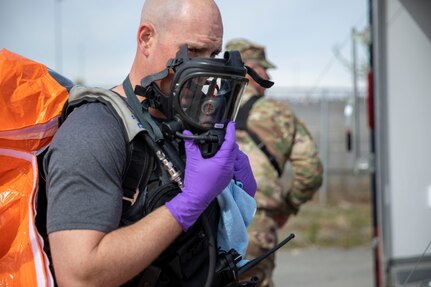 Sgt. Anthony Luiken, 103rd Civil Support Team, performs radio checks through his mask in preparation to respond to a simulated incident in a tower at the Anchorage Fire Training Center, May 19, in support of Exercise ORCA 2021. ORCA is a chemical, biological, radioactive, nuclear threats response exercise designed for participants to provide support in the aftermath of hazardous materials incidents. ORCA tests interoperability between agencies, increases opportunities for working relationships, and practices requests for assistance methods. Approximately 250 National Guardsmen from CST units in Alaska, California, Connecticut, Colorado, Idaho, Ohio, Oregon, Rhode Island, South Carolina, South Dakota, Washington, and Wisconsin are in Alaska to participate in Exercise ORCA 2021. Numerous support units and civilian agencies participated in the exercise as well. (U.S. Army National Guard photo by Spc. Grace Nechanicky)