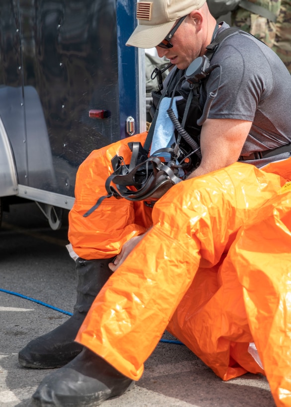 Sgt. Anthony Luiken, 103rd Civil Support Team, gets suited up and ready to respond to a simulated incident in a tower at the Anchorage Fire Training Center, May 19, in support of Exercise ORCA 2021. ORCA is a chemical, biological, radioactive, nuclear threats response exercise designed for participants to provide support in the aftermath of hazardous materials incidents. ORCA tests interoperability between agencies, increases opportunities for working relationships, and practices requests for assistance methods. Approximately 250 National Guardsmen from CST units in Alaska, California, Connecticut, Colorado, Idaho, Ohio, Oregon, Rhode Island, South Carolina, South Dakota, Washington, and Wisconsin are in Alaska to participate in Exercise ORCA 2021. Numerous support units and civilian agencies participated in the exercise as well. (U.S. Army National Guard photo by Spc. Grace Nechanicky)