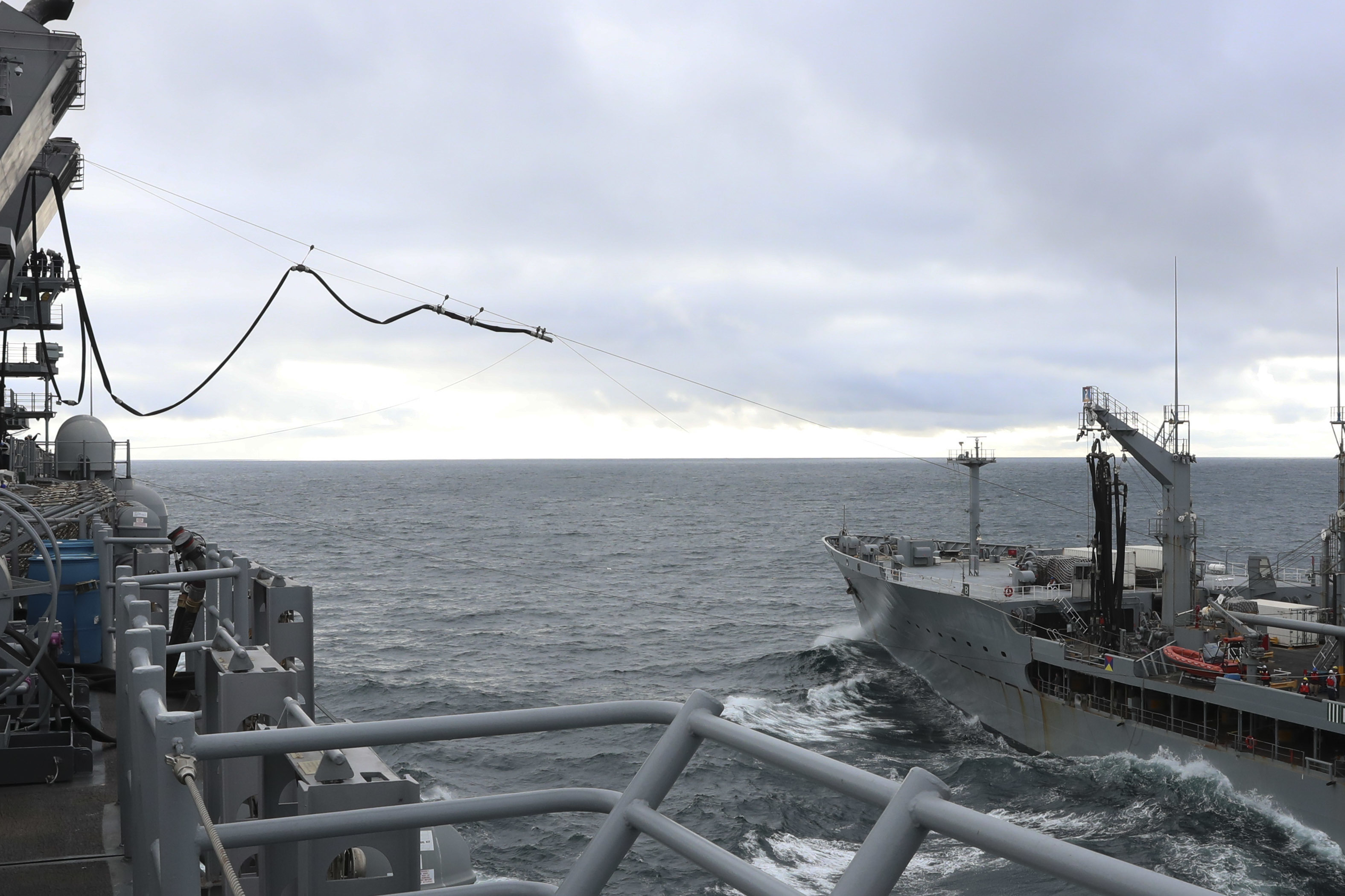 The amphibious assault ship USS Tripoli (LHA 7) sends a fuel line over to fleet replenishment oiler USNS Henry J. Kaiser (T-AO 187) during Tripoli�s first replenishment-at-sea (RAS), May 16, 2021.
