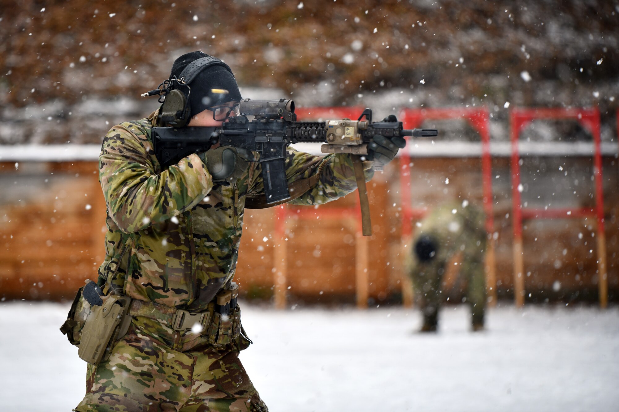 A soldier fires a weapon in a snowstorm.