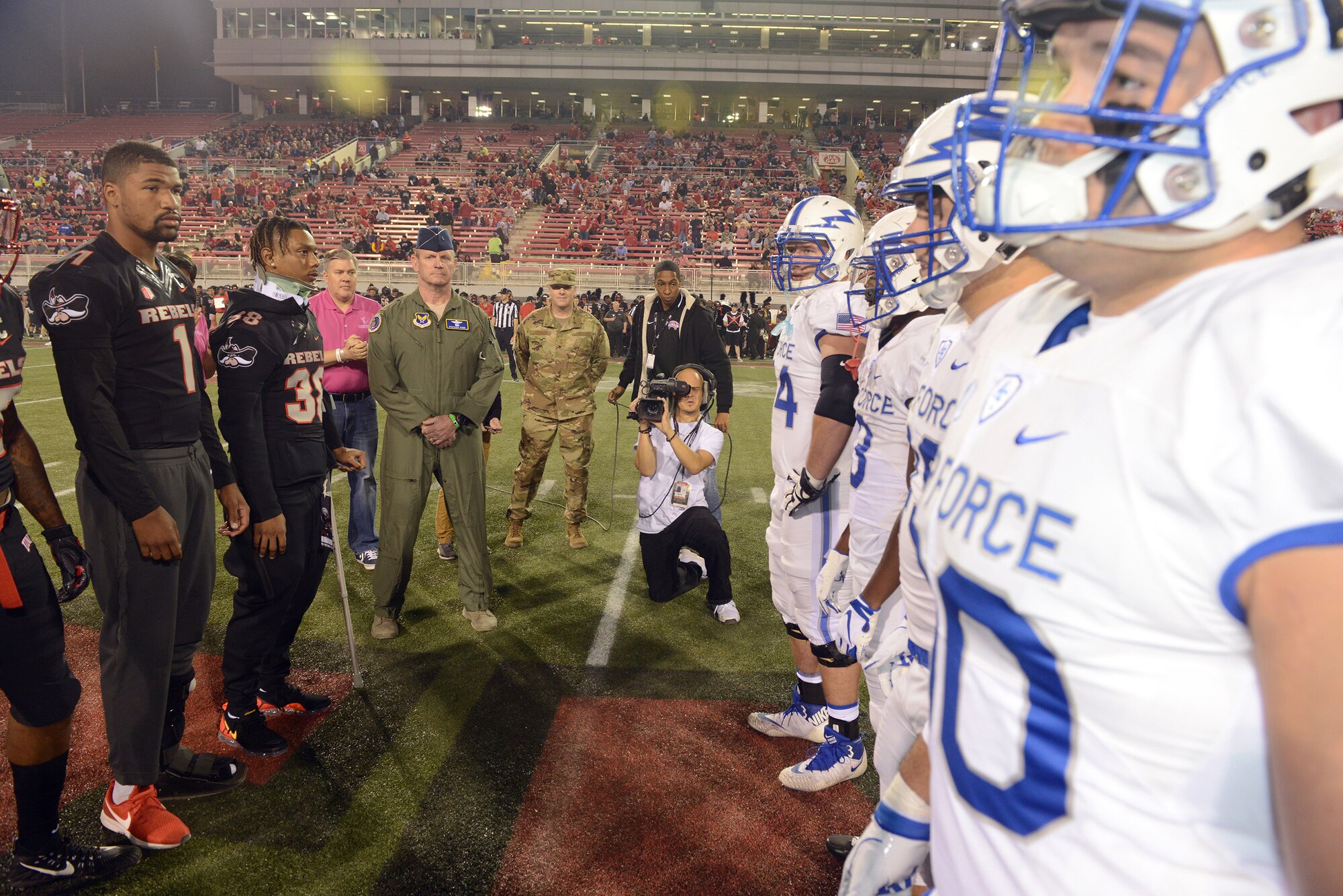 Now-retired Air Force Reserve Brig. Gen. Christian Funk served as the honorary captain for the Air Force Academy during a Falcons football game, Oct. 19, 2018. To his left is Chief Master Sgt. Michael Johnson, Air Force Recruiting Service chief of strategic marketing. Johnson and Funk began working sporting events in the Miami area when they were both assigned to Homestead Air Reserve Base, Florida.