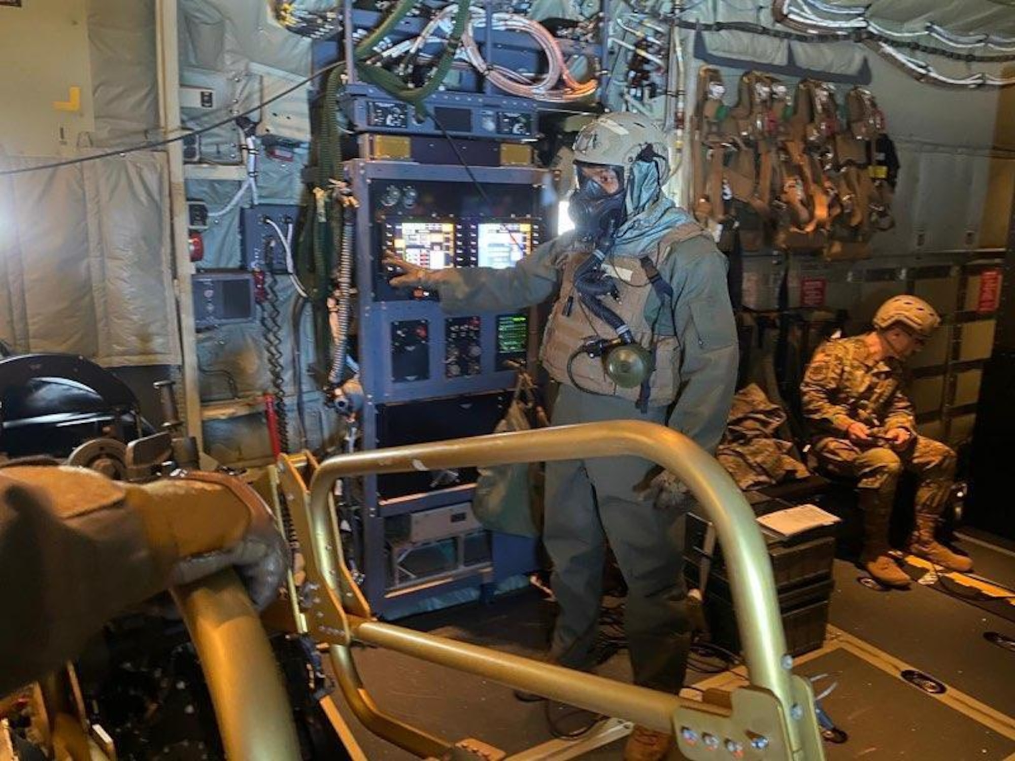 Airman in mask points while operating screen.