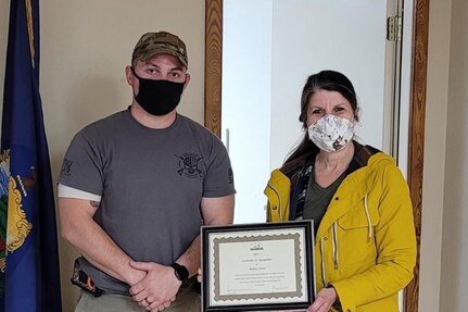 TSgt. Nathan Bourn, a munitions specialist assigned to the 158th Fighter Wing, is recognized by Beth Saradarian, executive director of the Rutland County Humane Society at the Poultney Fire Department, Poultney, VT.