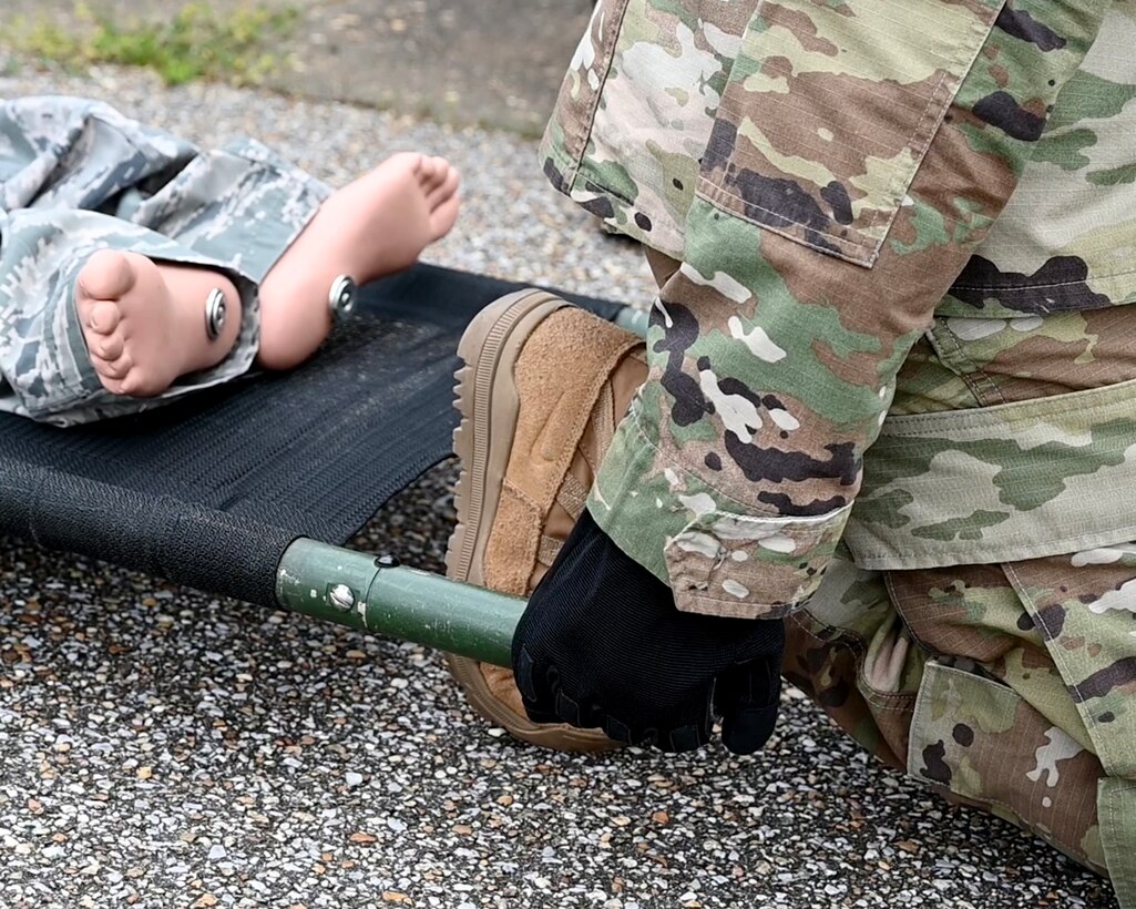 a person prepares to lift a stretcher