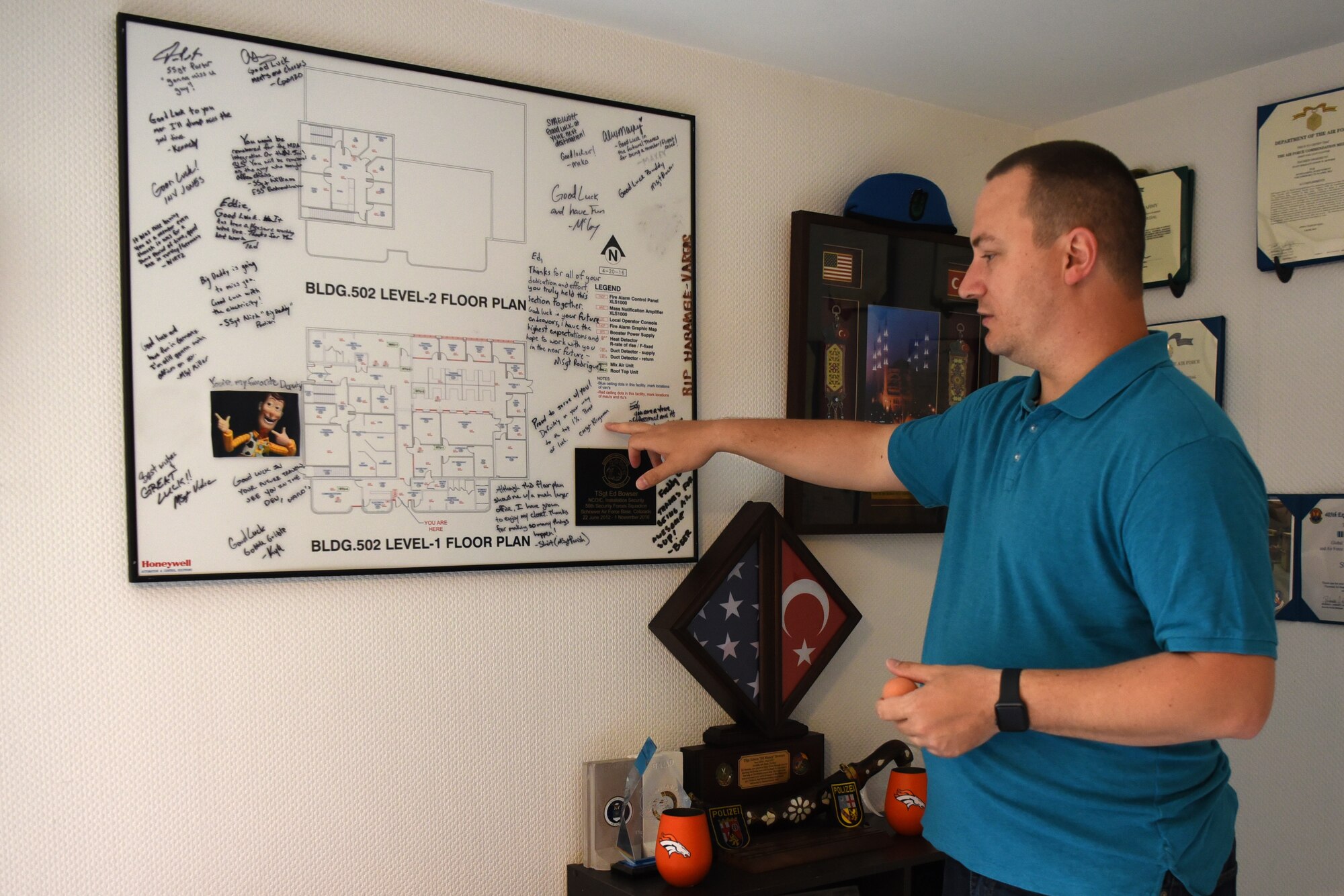 U.S. Air Force Tech. Sgt. Edwin Bowser, 569th U.S. Forces Police Squadron flight sergeant, tells the story behind the going away gift he received from a past duty station that now hangs on the wall of his home.