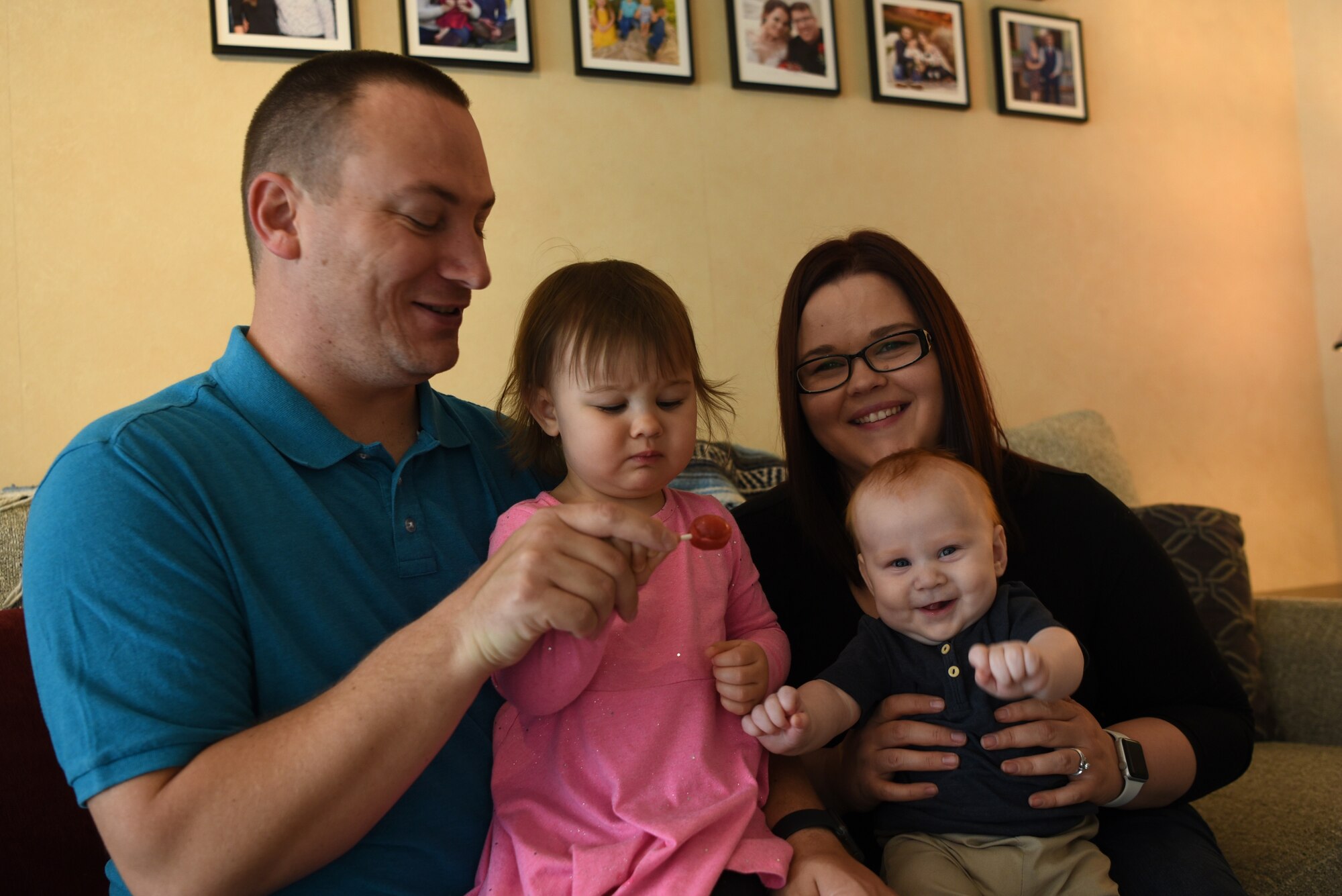 U.S. Air Force Tech. Sgt. Edwin Bowser, 569th U.S. Forces Police Squadron flight sergeant, sits with his wife, Mary, and their two children in an attempt to capture a family photo in his home