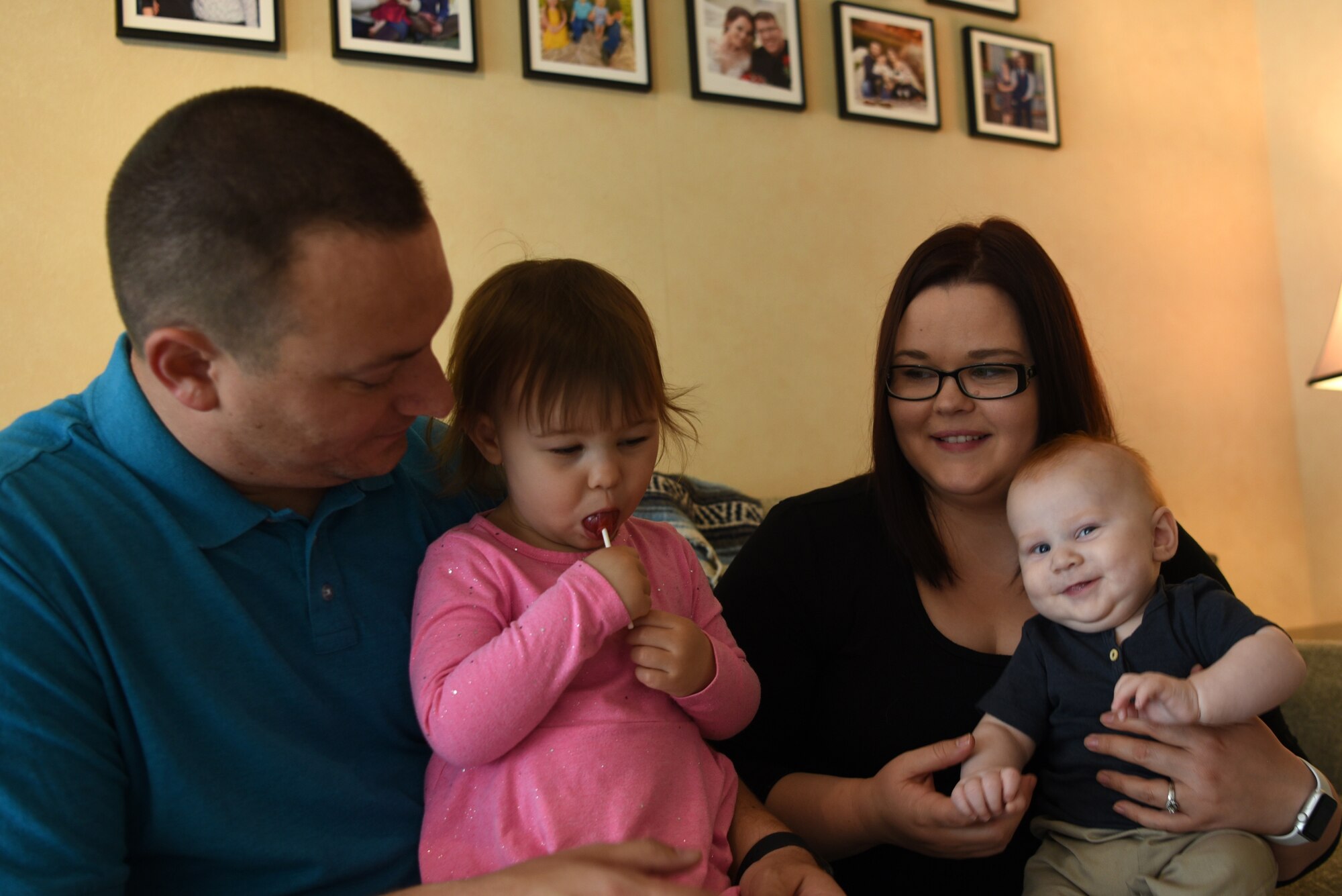 U.S. Air Force Tech. Sgt. Edwin Bowser, 569th U.S. Forces Police Squadron flight sergeant, sits with his wife, Mary, and their two children in an attempt to capture a family photo in his home.