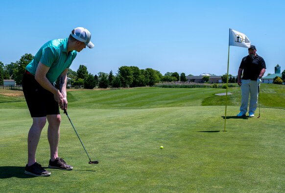 Staff Sgt. Matthew Cobb, 3rd Airlift Squadron loadmaster, putts a golf ball during the annual Bluesuiters Golf Tournament at Jonathan’s Landing Golf Course, Magnolia, Delaware, May 19, 2021. Twice a year, the tournament sponsors Airmen, matching them with local Chamber of Commerce members. This year, 33 Airmen participated for an opportunity to engage in team building activities and network. (U.S. Air Force photo by Airman 1st Class Cydney Lee)