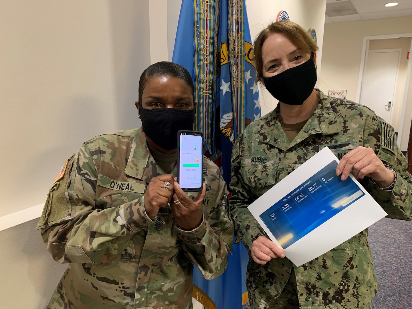 Two masked female officers display their relay mileage totals.