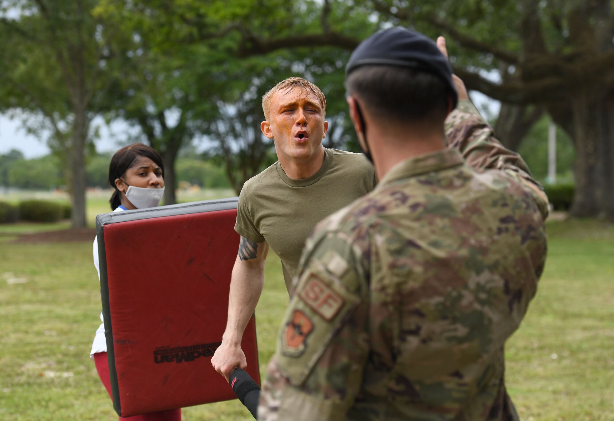U.S. Air Force Airman 1st Class Levi Rainbolt, 81st Security Forces Squadron installation entry controller, participates in oleoresin capsicum spray training with the assistance of Staff Sgt. John James, 81st SFS unit trainer, and officer Margie Ramsey, 81st SFS installation patrolman, at Keesler Air Force Base, Mississippi, May 18, 2021. The training is a required one-time exposure of the OC spray for all Security Forces members. (U.S. Air Force photo by Kemberly Groue)