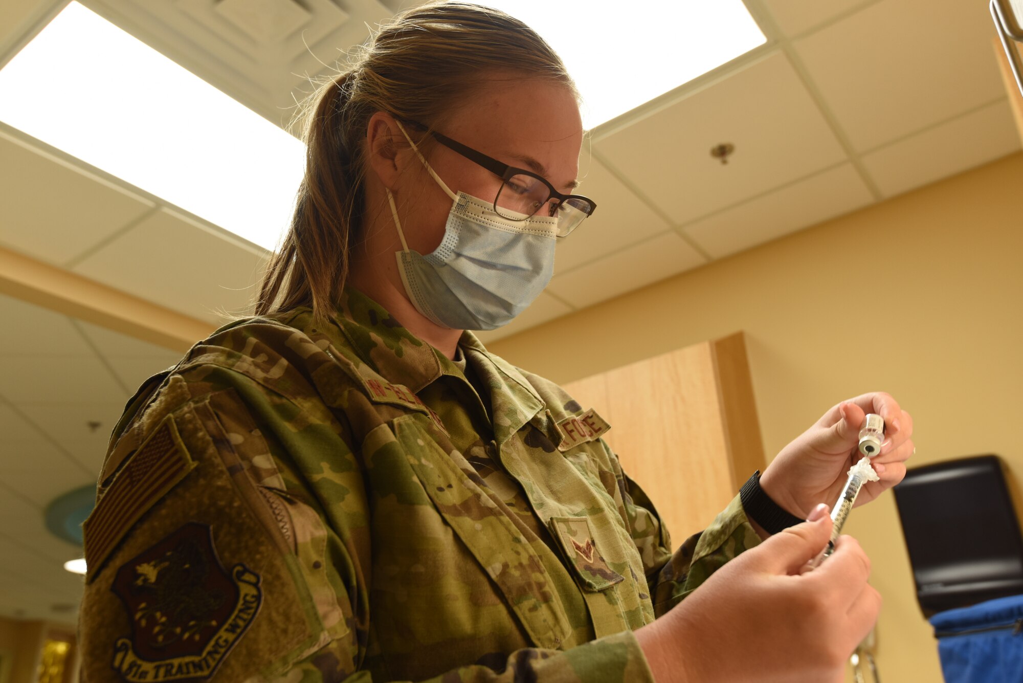 Airman 1st Class Megan Crow-Elmore, 81st Medical Group aerospace medical technician, prepares a syringe containing the Pfizer COVID-19 vaccine inside the Keesler Medical Center at Keesler Air Force Base, Mississippi, May 19, 2021. Crow-Elmore is part of the COVID-19 Task Force, made up of medical workers from various units in response to the pandemic. (U.S. Air Force photo by Airman 1st Class Jasmine Galloway)