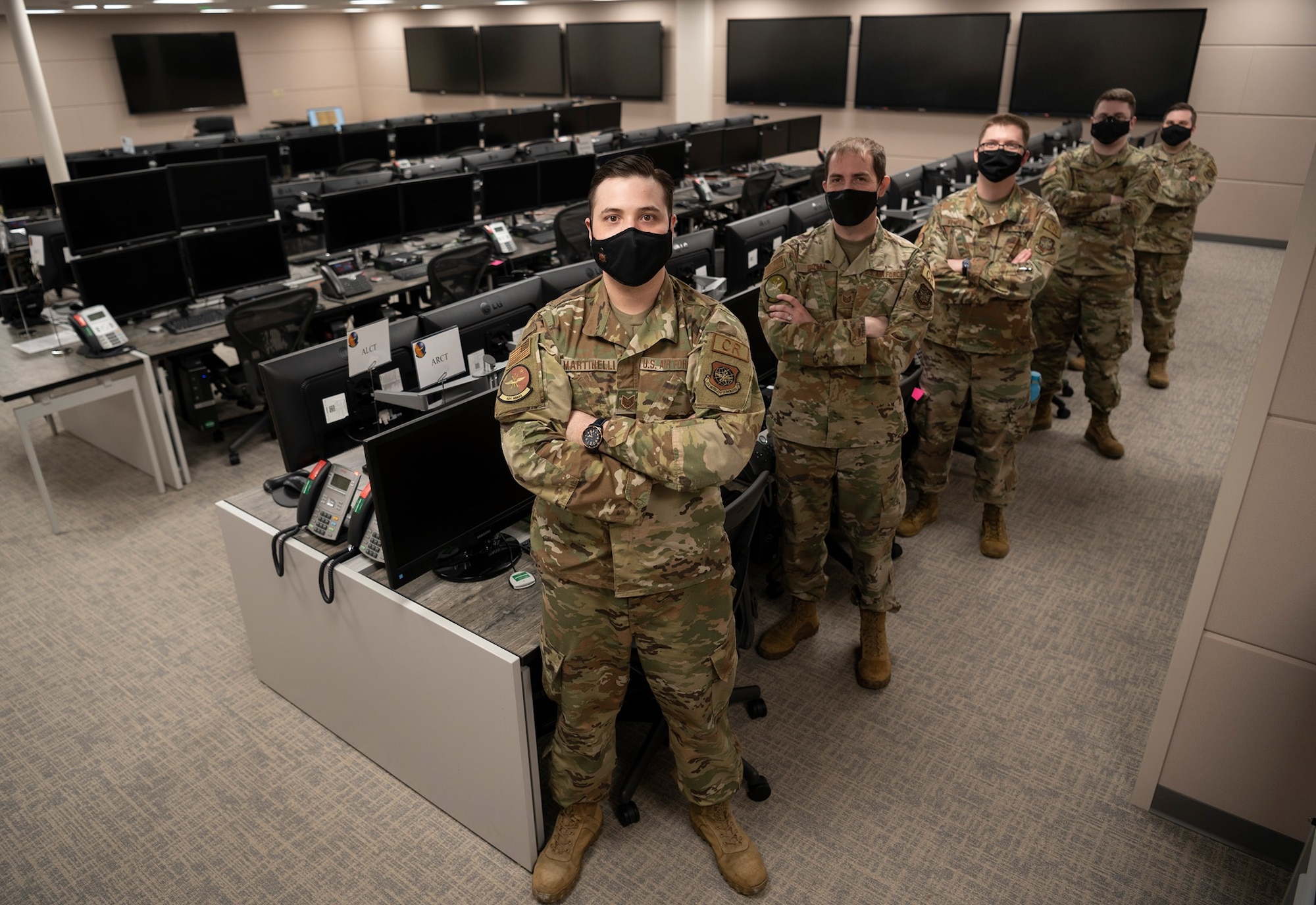 Airmen with the 621st Air Mobility Operations Squadron pose for a group photo April 24, 2021 at the newly renovated weapon system suite at Joint Base McGuire-Dix-Lakehurst, New Jersey. The weapon system suite empowers air mobility command and control experts to execute air operations remotely, supporting combatant commanders across a full range of military operations. (U.S. Air Force photo by Tech. Sgt. Luther Mitchell Jr.)