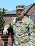 Spc. Mike Liu stands for a photo in front of the 124th Regional Training Institute at Camp Johnson, Vermont, May 20, 2021. Liu, a native of Anshan, China, joined the Vermont Army National Guard through the Military Accessions Vital to the National Interest program, which allows non-U.S. citizens with certain skills to enlist and apply for citizenship. He currently attends Army Officer Candidate School and plans to become an ordnance officer when he graduates in 2022. (U.S. Army National Guard photo by Duffy Jamieson)