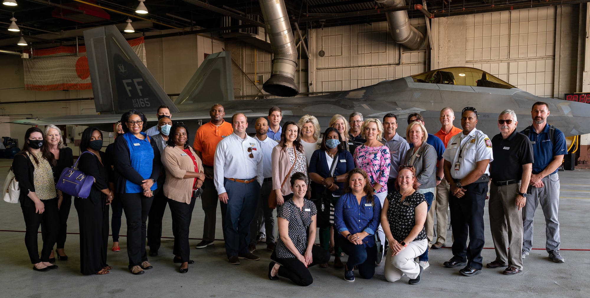 Members of the Learn, Explore, Absorb and Disseminate (LEAD) Peninsula group pose for a photo with an F-22 Raptor aircraft at Joint Base Langley-Eustis, Virginia, May 20, 2021. The LEAD program participants visited JBLE to immerse themselves in various functions and learn the role JBLE plays within the Virginia Peninsula community.
