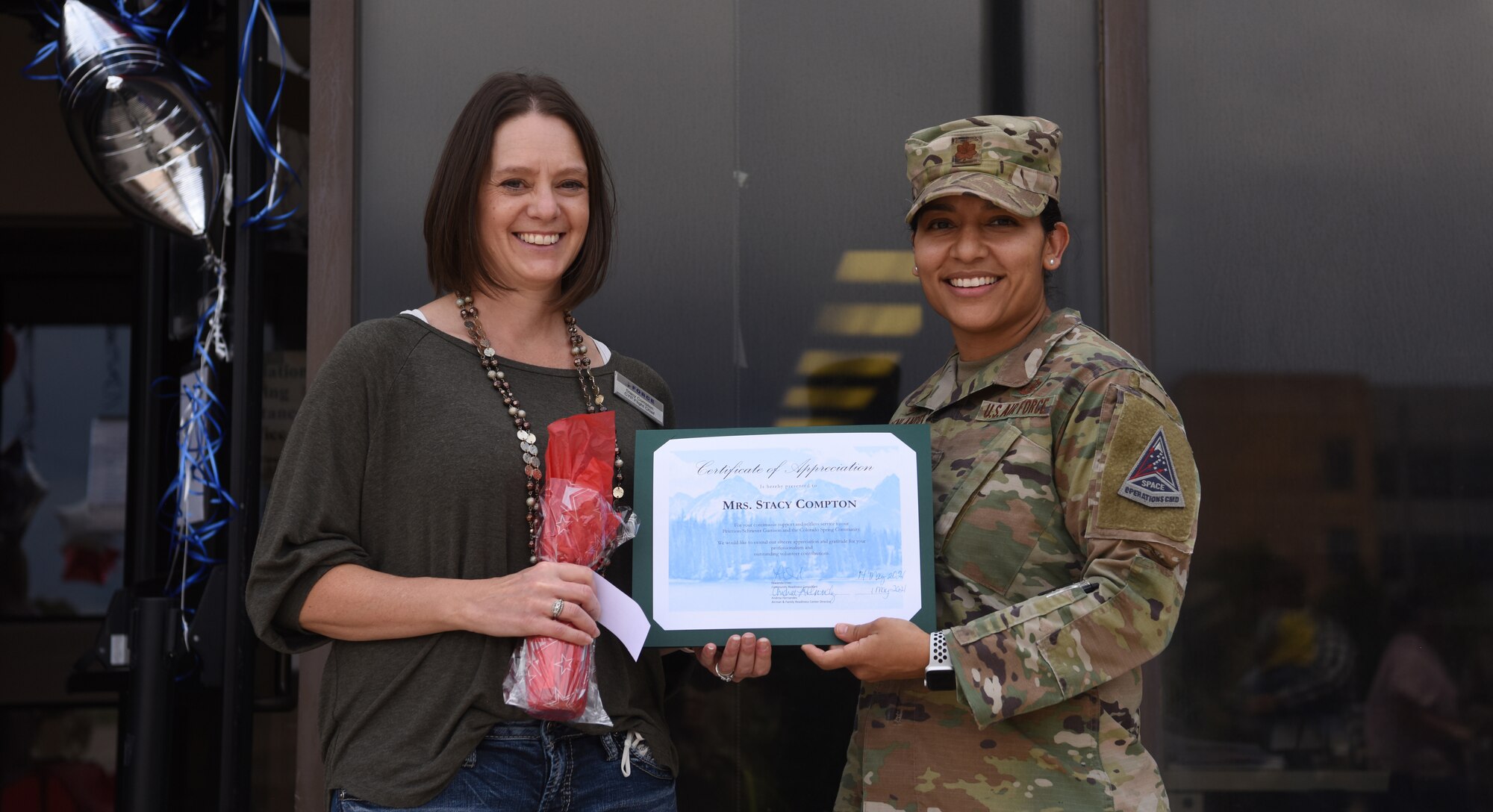 Stacy Compton, 50th Force Support Squadron Child and Youth Flight chief, is recognized by Maj. Gisselle Oppenlander, 50th Force Support Squadron commander, for her support and service as a volunteer at Schriever Air Force Base, Colorado, May 14, 2021. Volunteers were recognized by the Airman and Family Readiness Center for their dedication and support to helping the Front Range community in honor of National Volunteer Week. (U.S. Space Force photo by Airman 1st Class Joshua Fontenot)