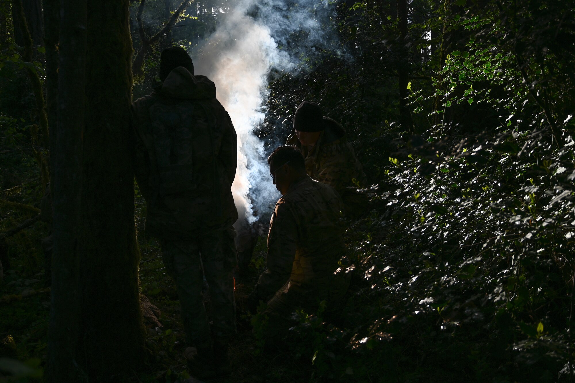 U.S. Soldiers assigned to Alpha Company 2-158 , 2nd Battalion, 158th Aviation Regiment, start an evasion fire at Joint Base Lewis-McChord, Washington, May 18, 2021. 62nd Operations Support Squadron survive, evade, resist, and escape specialists hosted an evasion exercise for A Co 2-158, where they practiced evasion living utilizing fire, shelter and camouflage paint. (U.S. Air Force photo by Airman 1st Class Callie Norton)