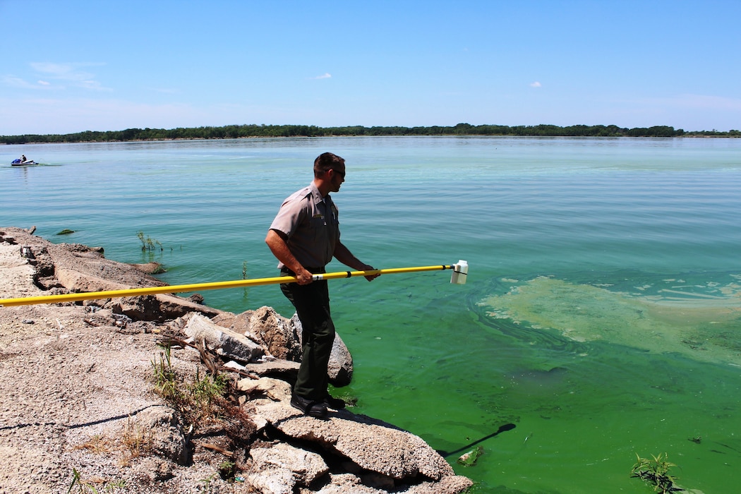 Kyle R. Ruona, a park ranger at Perry Lake in Kansas, takes a water sample during blue-green algae training held at Milford Lake July 9, 2014. Photo by Marvin G. Boyer.