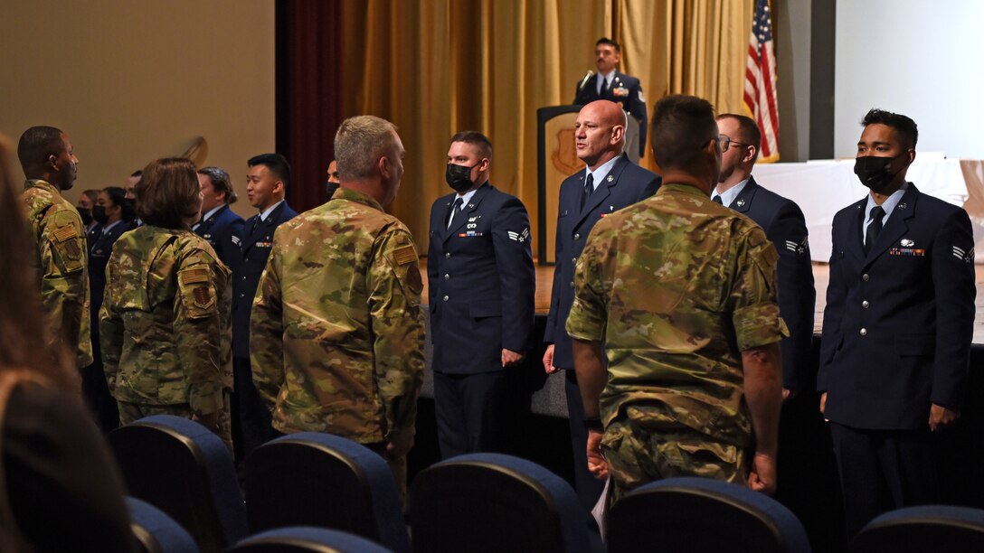 Airman Leadership School graduates, Class 21-D, sing the Air Force song during their ALS graduation ceremony at the Base Theater, on Goodfellow Air Force Base, Texas, May 20, 2021. ALS focuses on developing leadership abilities, the profession of arms, and building effective communication. (U.S. Air Force photo by Senior Airman Abbey Rieves)