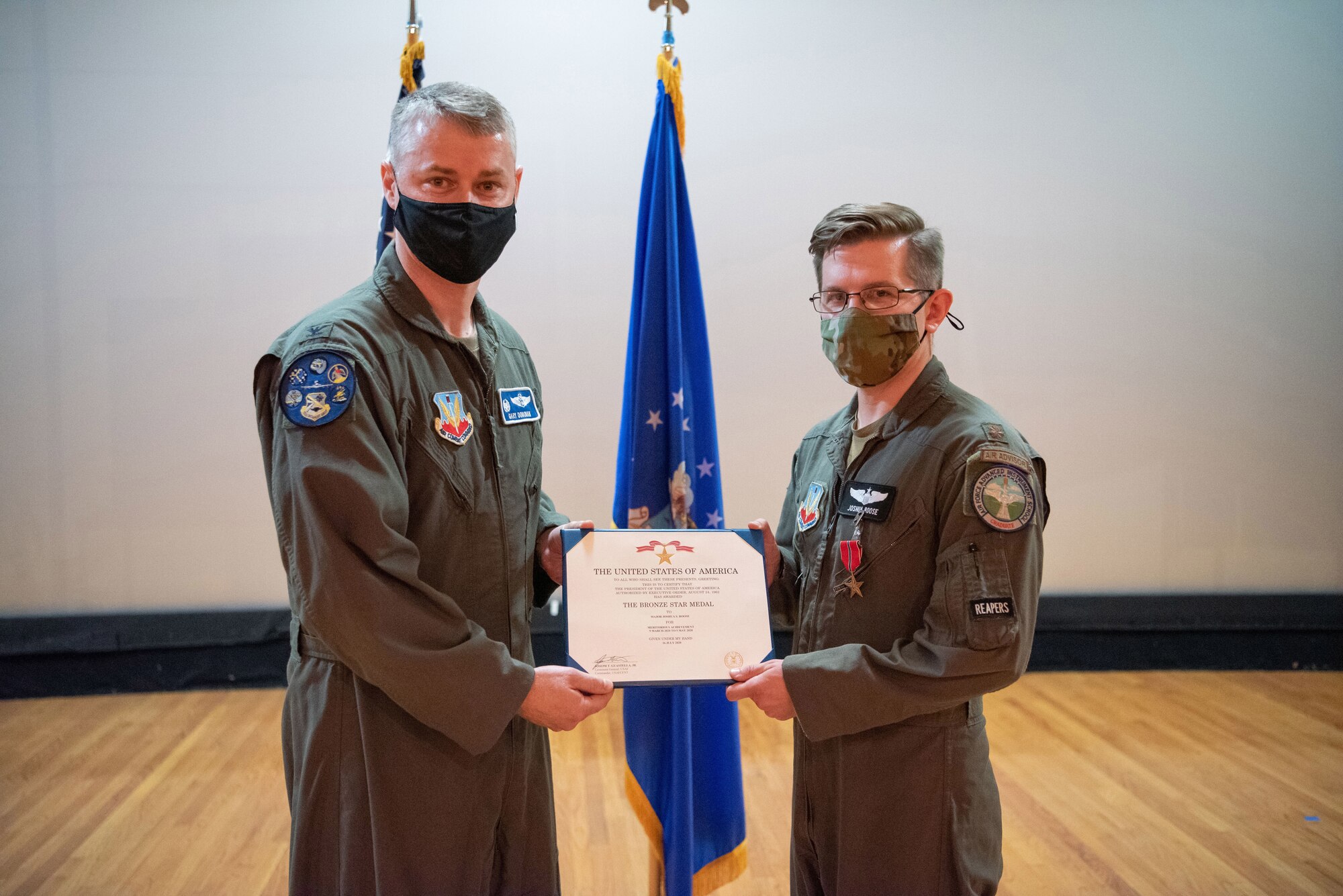 Two Airmen holding a certificate