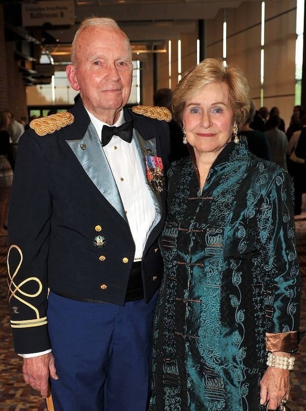 An elderly man in Army dress uniform and an elderly woman pose for a photo.