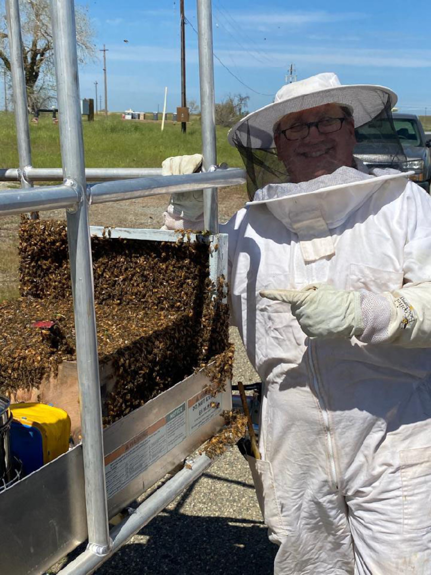 Blaze Baker, 9th Civil Engineer Squadron installation management flight chief, poses with a swarm of bees he caught at Beale Air Force Base, California, April 7, 2021.