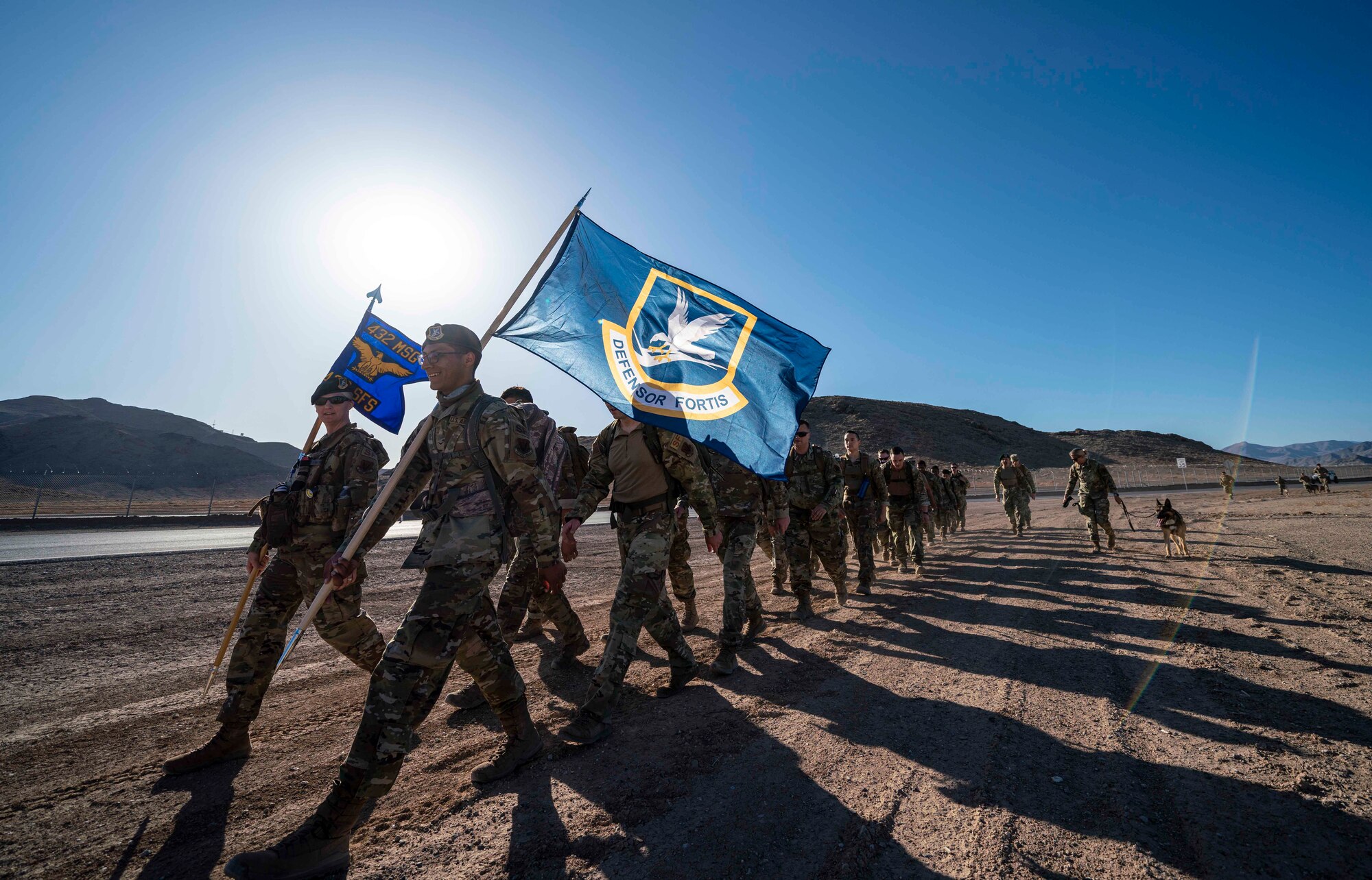 Airmen carry flags during a ruck march.