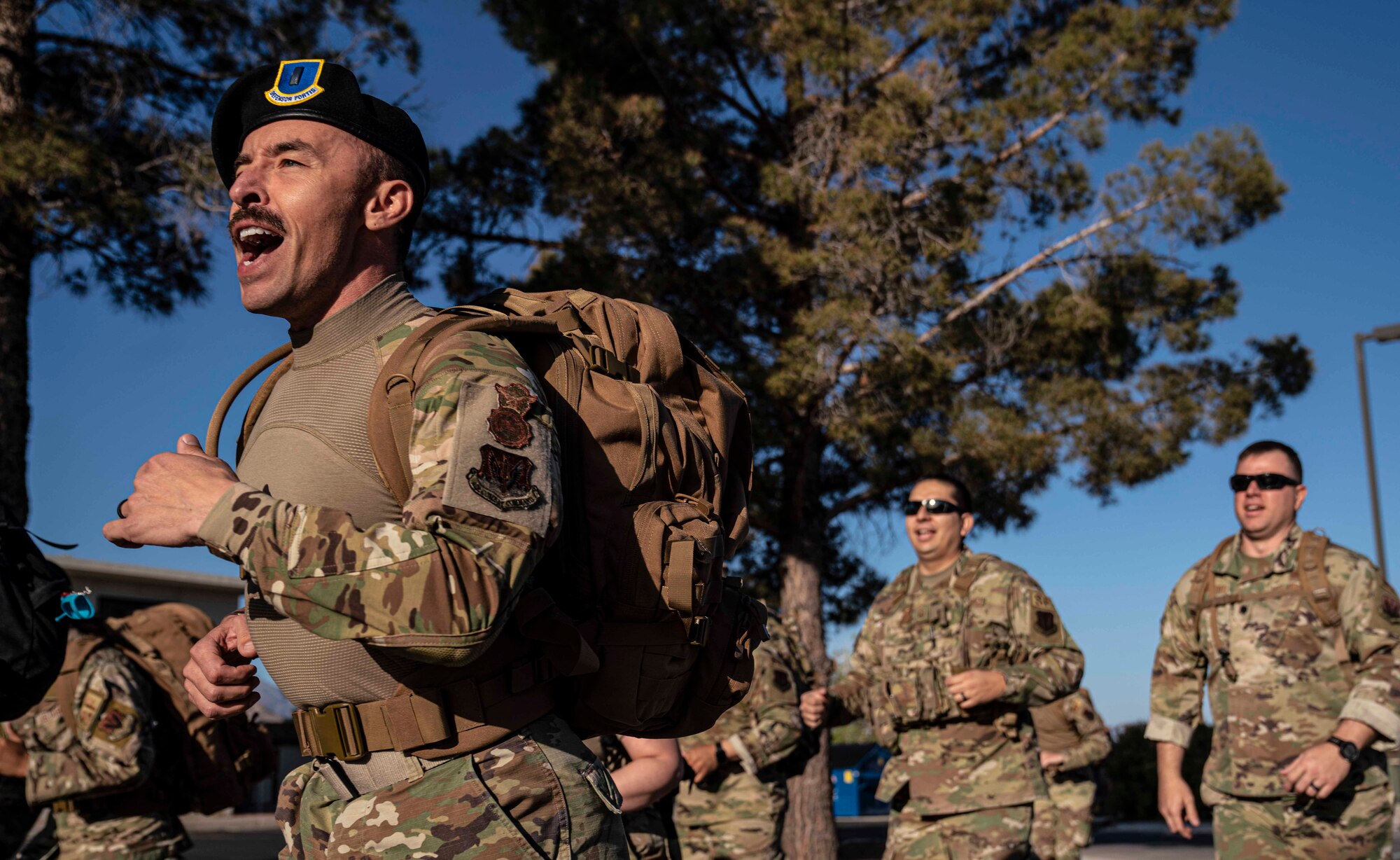 Airmen run and sing during a ruck march.