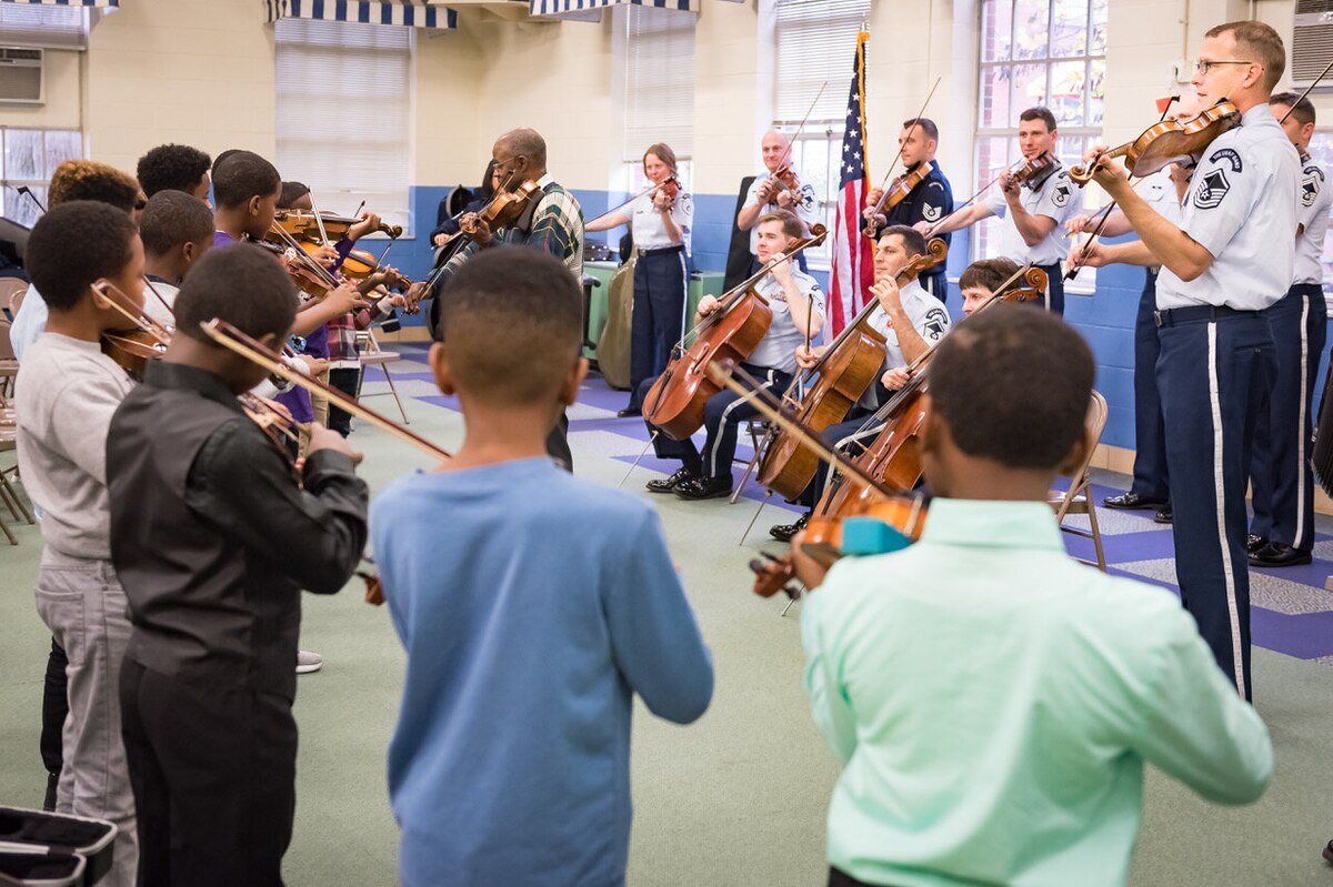 Members of the U.S. Air Force Strolling Strings perform with elementary string students during an AIM school visit. (U.S. Air Force photo by Chief Master Sgt. (ret.) Bob Kamholz)