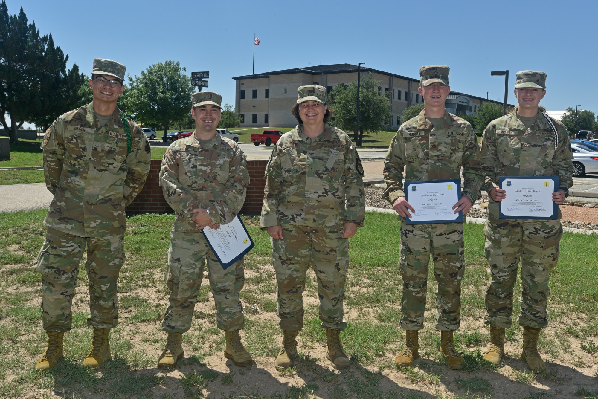 U.S. Air Force Col. Angelina Maguinness, 17th Training Group commander, and students from across the 17th TRG pose for a picture outside of the Brandenburg Hall on Goodfellow Air Force Base, Texas, May 21, 2021. Each student was nominated to receive their award based on votes received by fellow students and instructors of their respective squadrons. (U.S. Air Force photo by Senior Airman Ashley Thrash)
