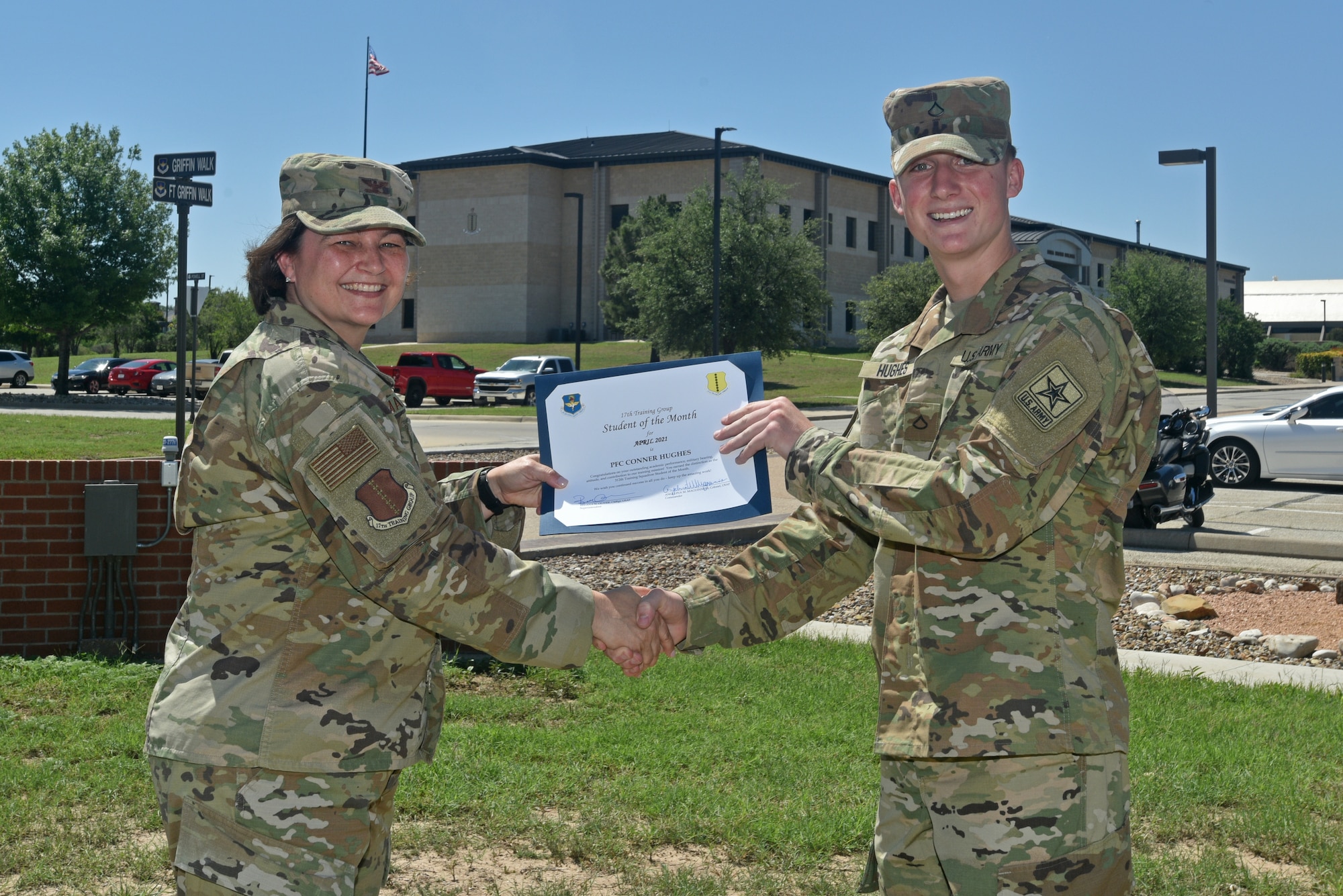 U.S. Air Force Col. Angelina Maguinness, 17th Training Group commander, presents U.S. Army Pfc. Conner Hughes, 312th Training Squadron student, the 17th TRG Student of the Month award for April 2021, outside of the Brandenburg Hall on Goodfellow Air Force Base, Texas, May 21, 2021. The 312th TRS’s mission is to train, develop, and inspire warriors to deliver fire emergency services and nuclear treaty monitoring for the Department of Defense and our international partners. (U.S. Air Force photo by Senior Airman Ashley Thrash)