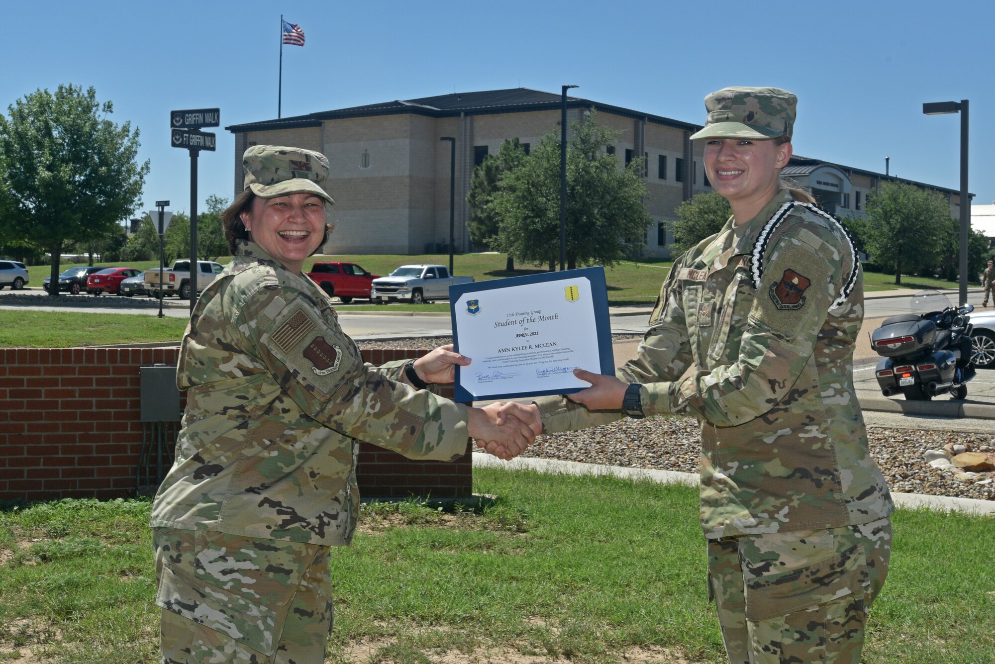 U.S. Air Force Col. Angelina Maguinness, 17th Training Group commander, presents Airman Kylee Mclean, 315th Training Squadron student, the 17th TRG Student of the Month award for April 2021, outside of the Brandenburg Hall on Goodfellow Air Force Base, Texas, May 21, 2021. Mclean worked hard for her award and has shown her dedication to her squadron and the training she received at Goodfellow. (U.S. Air Force photo by Senior Airman Ashley Thrash)