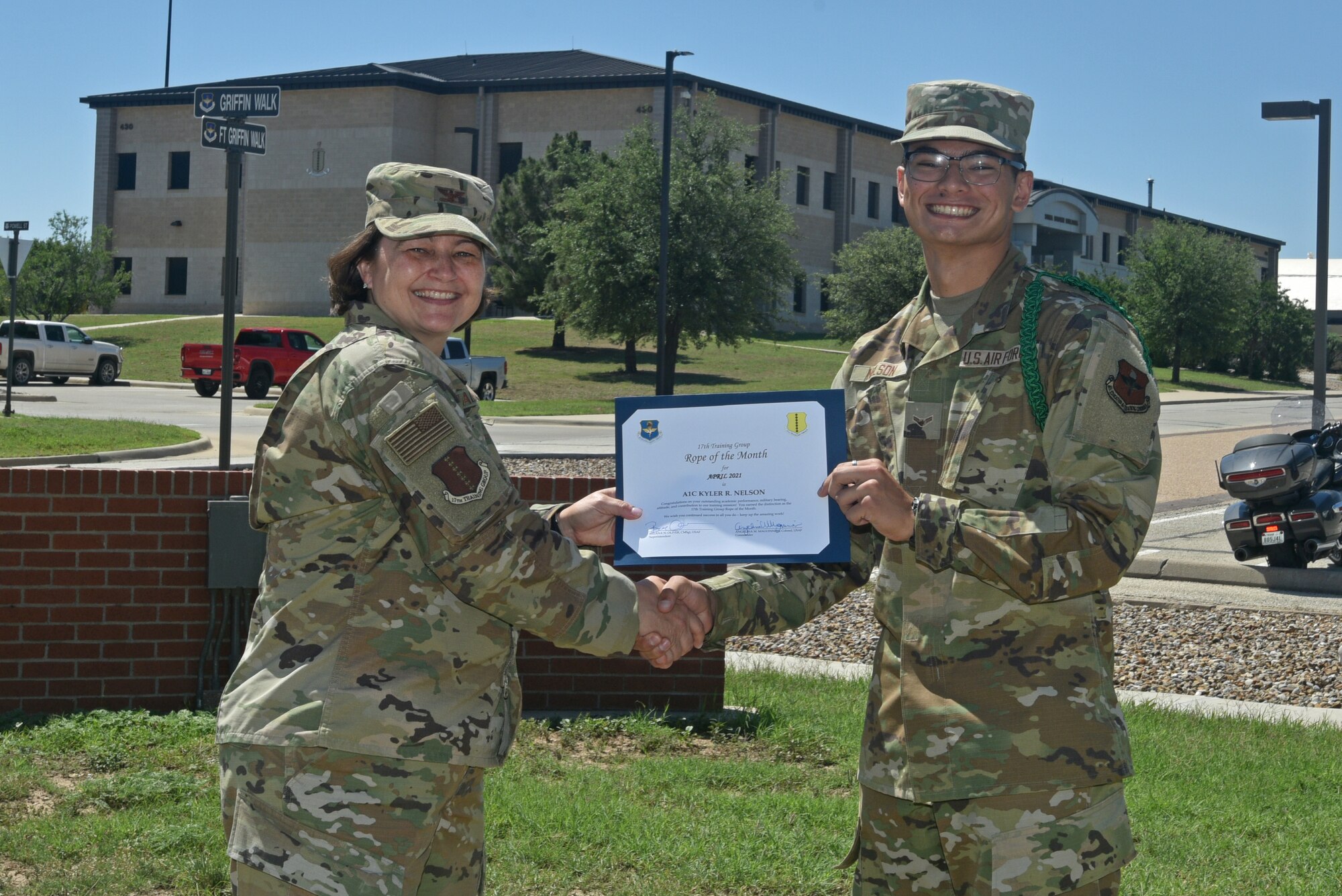 U.S. Air Force Col. Angelina Maguinness, 17th Training Group commander, presents Airman 1st Class Kyler Nelson, 315th Training Squadron student, the 17th TRG Rope of the Month award for April 2021, outside of the Brandenburg Hall on Goodfellow Air Force Base, Texas, May 21, 2021. Military Training Leaders present different ropes to Airmen who display exceptional qualities to lead their peers. Nelson was recognized for his hard work and dedication in his rope duties. (U.S. Air Force photo by Senior Airman Ashley Thrash)