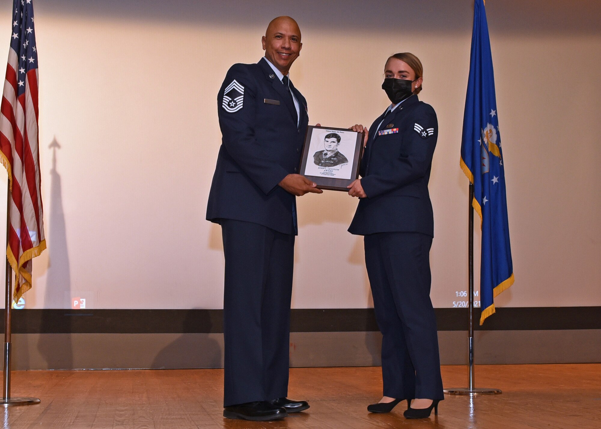 U.S. Air Force Chief Master Sgt. Edward Vargas, 47th Medical Group superintendent, at Laughlin Air Force Base, Texas, presents Senior Airman Madison West, 17th Comptroller Squadron financial analysis technician, the John L. Levitow award during West’s Airman Leadership School graduation ceremony at the Base Theater, on Goodfellow Air Force Base, Texas, May 20, 2021. The John L. Levitow award is the highest award possible in professional military education and is based upon all performance tasks, peer stratifications and the capstone exercise. (U.S. Air Force photo by Senior Airman Abbey Rieves)