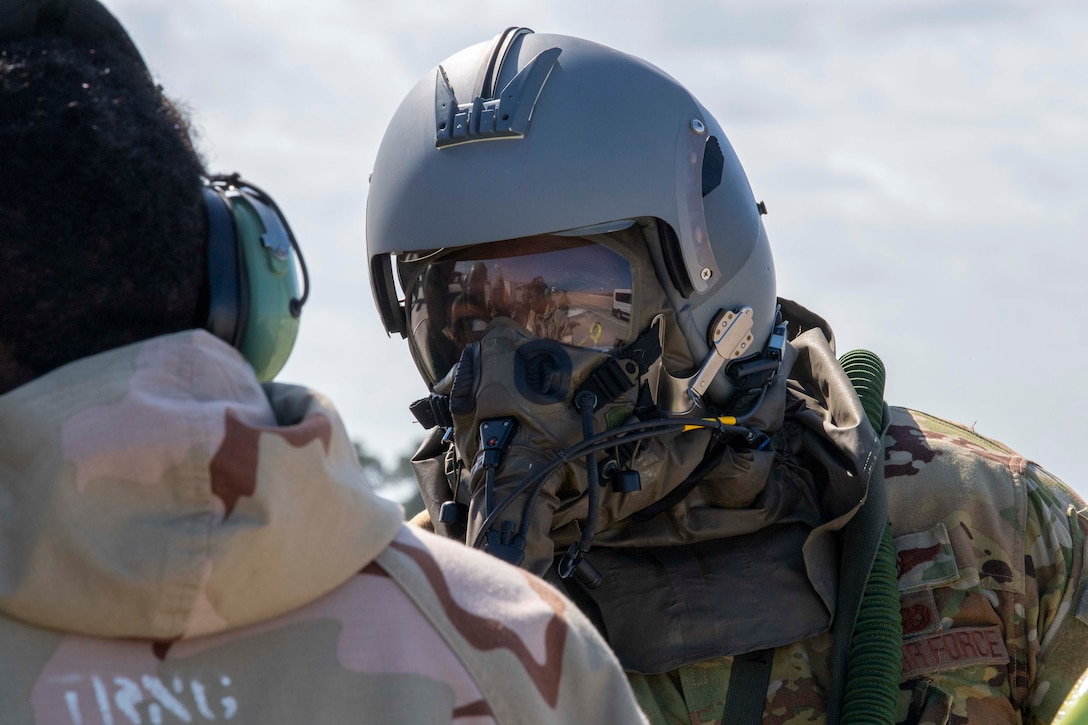 A KC-135 Stratotanker aircraft pilot with the 91st Air Refueling Squadron (ARS) right, speaks to a maintainer with the 6th Aircraft Maintenance Squadron (AMXS) left, on the flight line during a large-scale readiness exercise  at MacDill Air Force Base, Florida, May 20, 2021. The 91st ARS and the 6th AMXS worked alongside each other during phase two of the LRE to ensure KC-135 Stratotankers were up and running in a simulated contested environment. (U.S. Air Force photo by Airman 1st Class Hiram Martinez)