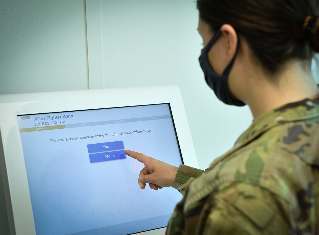 Senior Airman Lexi Smith 301st Fighter Wing Force Support Squadron customer support technician demonstrates the check-in process using the wing's new Queue Kiosk system at U.S. Naval Air Station Joint Reserve Base Fort Worth, Texas. This system will allow a customer to select any support agency within the entire FSS building to include support from finance, legal, retention and career counseling among others. (U.S. Air Force photo by Jeremy Roman)