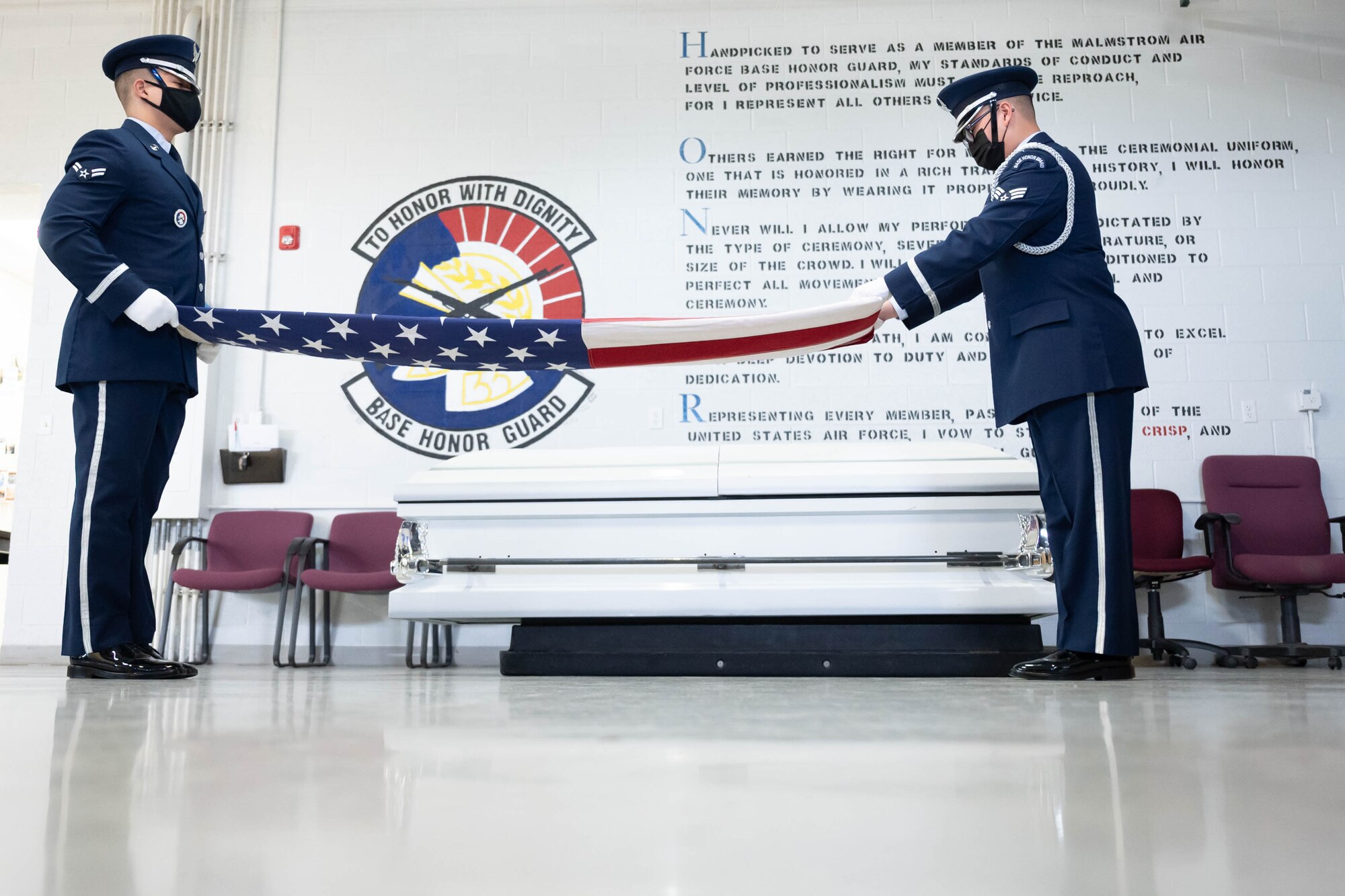 Airman 1st Class Ashton Martin, left, 341st Missile Security Forces Squadron defender and Senior Airman Cho Yang, right, 841st Missile Security Forces Squadron defender, both current 341st Missile Wing Base Honor Guard honor guardsmen, practice folding an American Flag during training April 13, 2021, at Malmstrom Air Force Base, Mont.