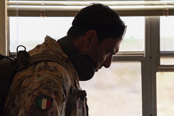 A man stands by a window silhouetted by the sunlight.