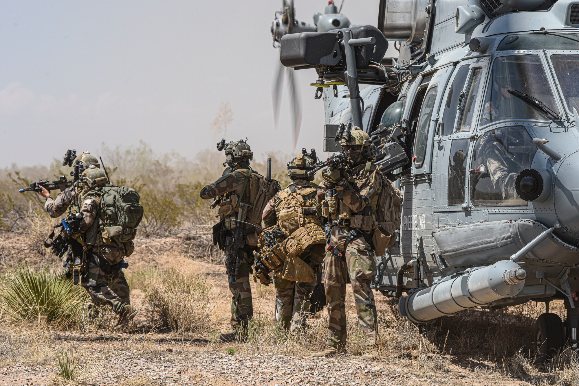 A group of soldiers board a helcopter.