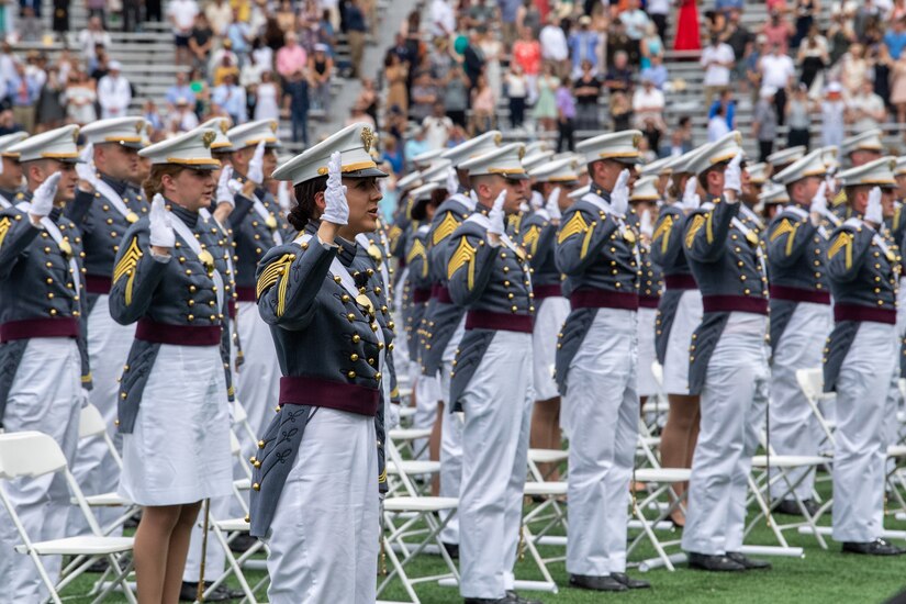 U.S. Military Academy cadets stand with their right hand raised during a ceremony.