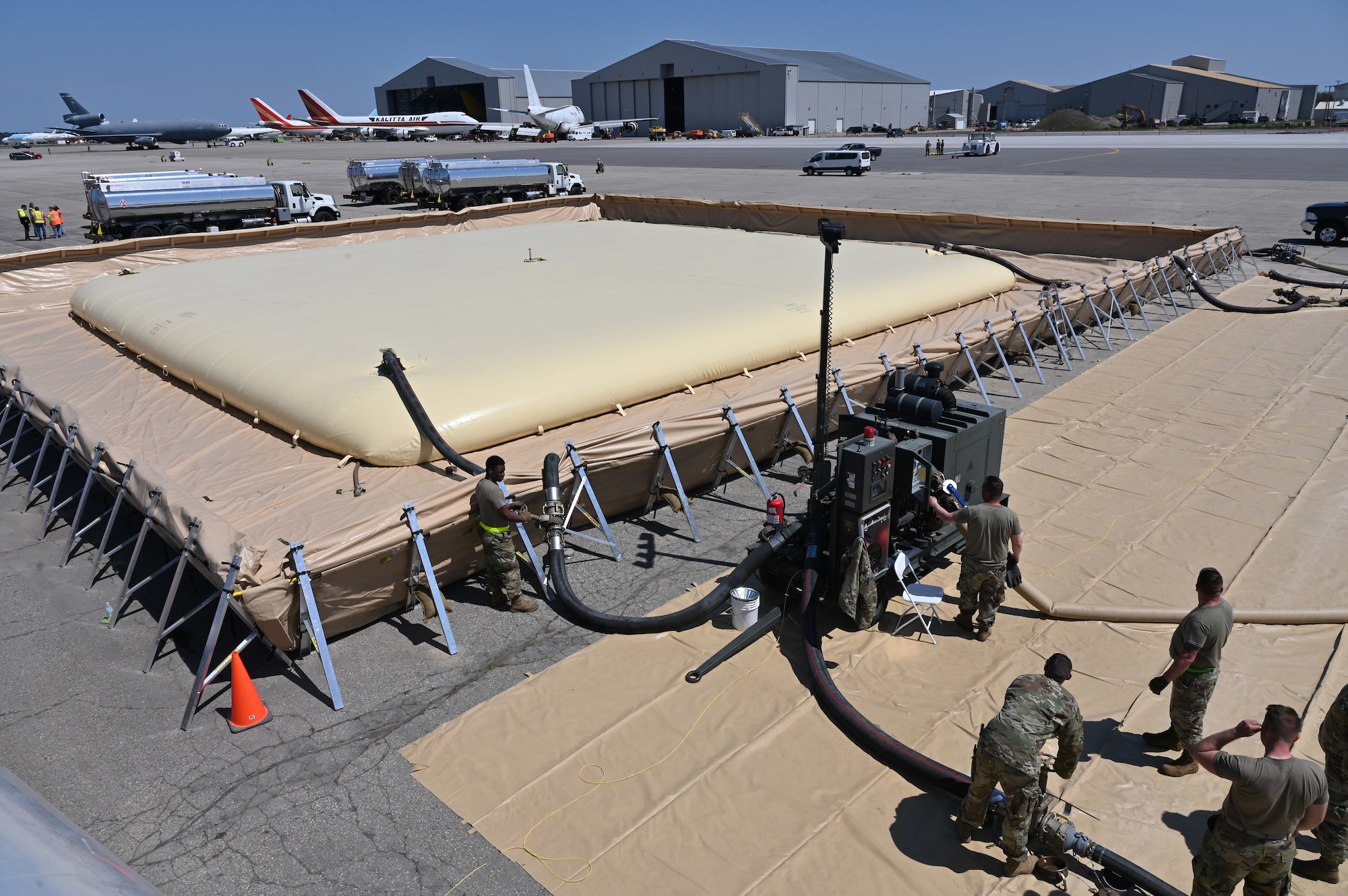 Air Mobility Command petroleum, oils and lubricants Airmen pump fuel into a Fuels Operational Readiness Capability Equipment mobile fuel bladder during Exercise Mobility Guardian at Oscoda-Wurtsmith Airport, Oscoda, Michigan, May 18, 2021. The 210,000-gallon fuel bladder is designed to be used in an austere location to refuel aircraft and mobile fuel trucks. (U.S. Air Force photo by Senior Airman Aaron Irvin)