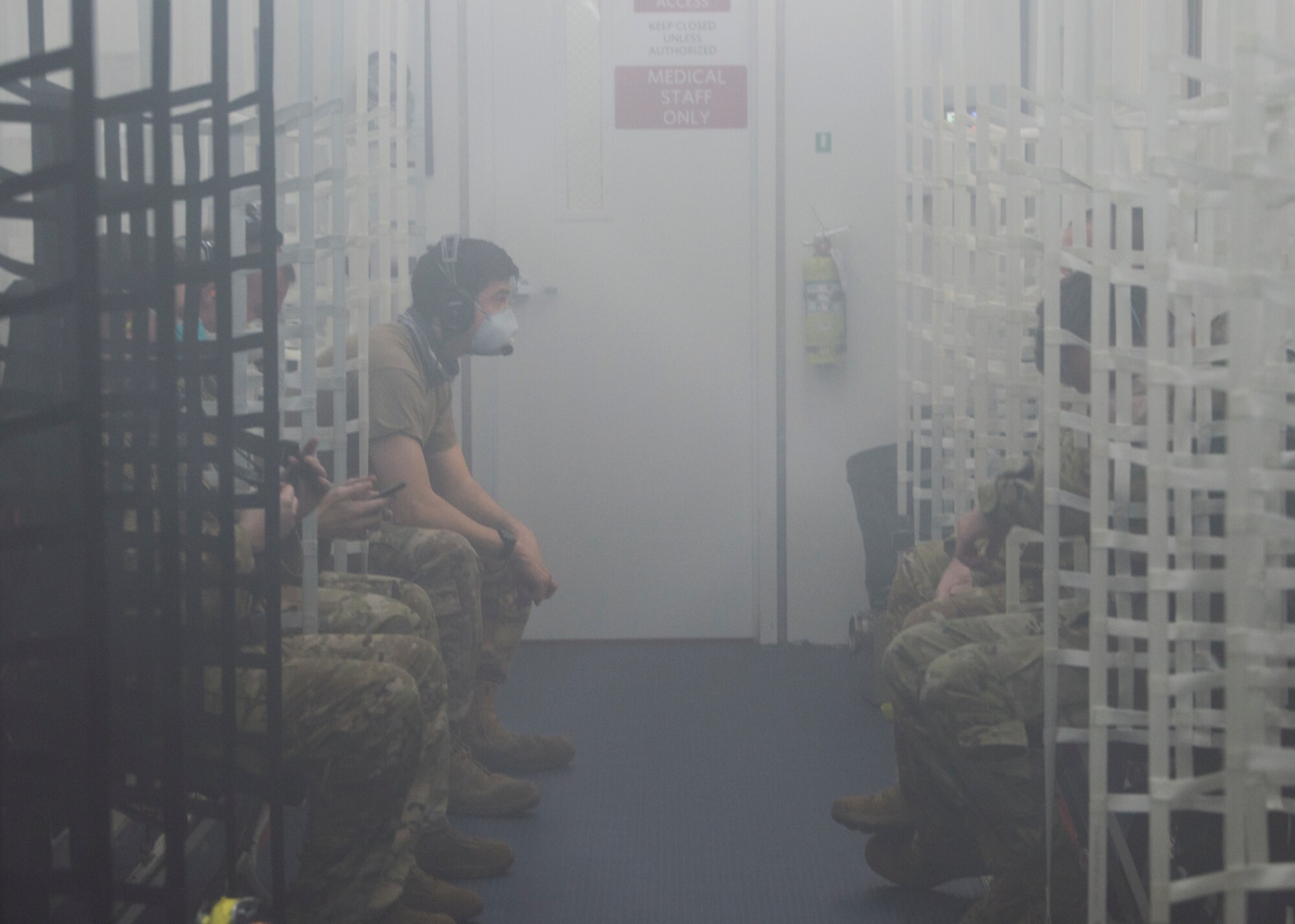 U.S. Airmen converse inside a Negatively Pressurized Conex prototype during in-flight testing on a C-17 Globemaster III, April 30, 2020. The NPC was rapidly developed and designed to fit inside both C-5 and C-17 aircraft to enable safe transport of up to 28 passengers, as well as teams of medical professionals to medical facilities around the globe. (U.S. Air Force photo by Staff Sgt. Chris Drzazgowski)