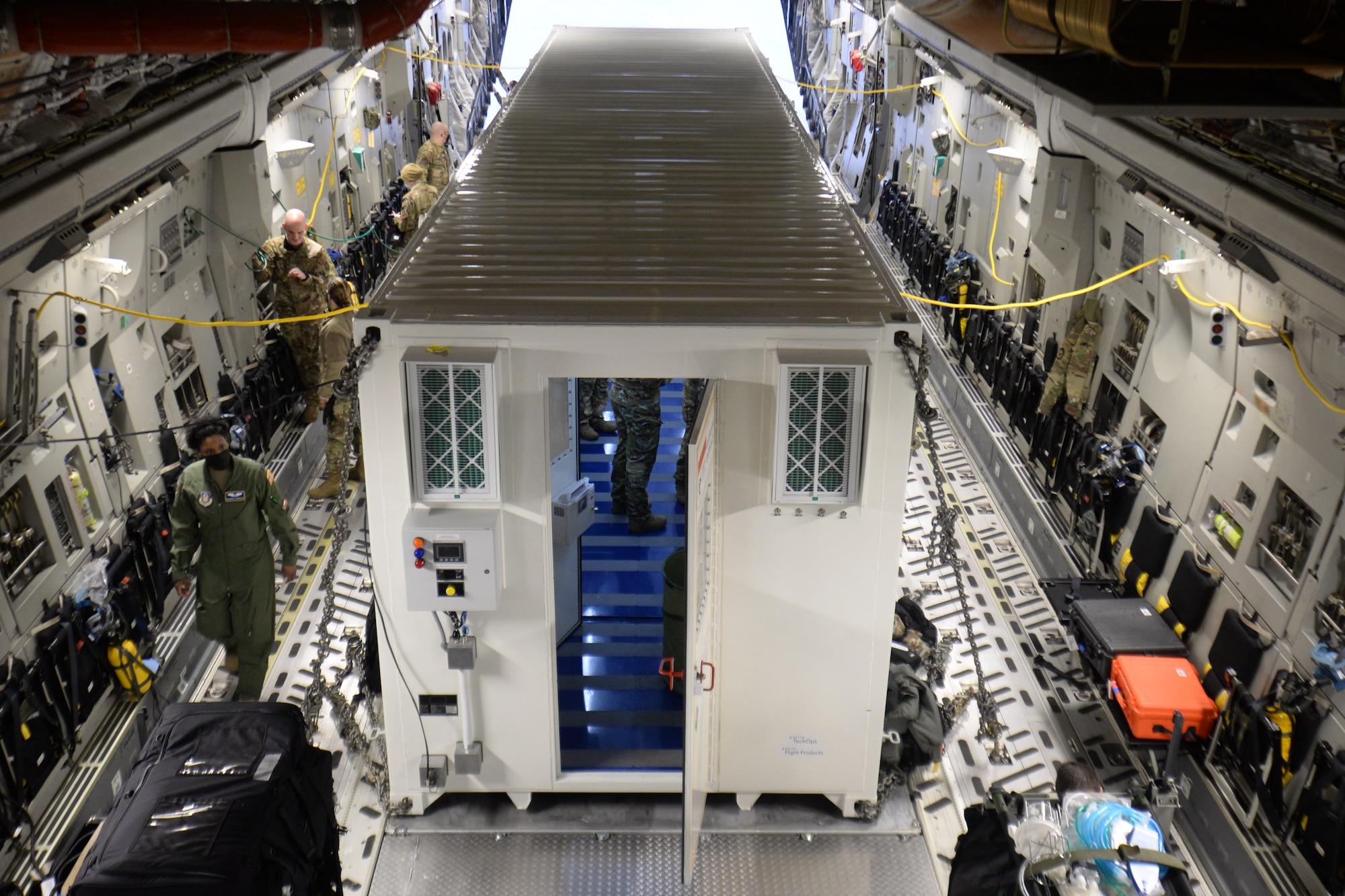 U.S. Air Force Airmen assigned to the 10th Expeditionary Aeromedical Evacuation Flight familiarize themselves with a Negatively Pressurized Conex secured inside a C-17 Globemaster III aircraft during a training at Ramstein Air Base, Germany, Jan. 30, 2021. Patients are brought onboard the aircraft and kept in the biocontainment unit during flight to isolate them from the rest of the crew. The NPC used in the training is permanently assigned to the 521st Air Mobility Operations Wing and offers on-hand infectious disease transport capabilities to Europe and Africa. (U.S. Air Force photo by Airman 1st Class Daniel Sanchez)