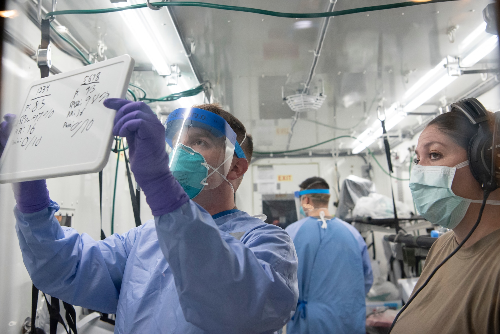 U.S. Air Force 2nd Lt. Edward Osborn (left), 379th Expeditionary Aeromedical Evacuation Squadron flight nurse, trains in the Negatively Pressurized Conex- Lite (NPC-L) during a static training at Al Udeid Air Base, Qatar, Aug. 7, 2020. The NPC-lite is the latest isolated containment chamber developed for intra-theater airlift of individuals with infectious diseases like COVID-19 and is designed to fit inside a C-130 Hercules aircraft (U.S. Air Force photo by Senior Airman Ashley Perdue)