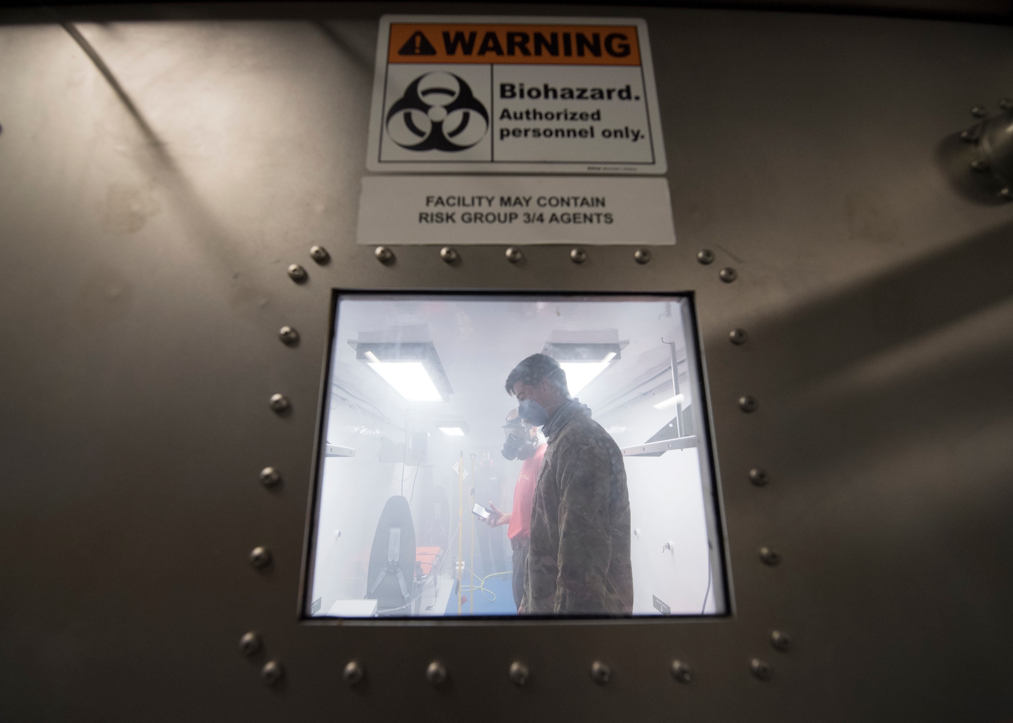 U.S. Air Force Capt. Conor Favo, 28th Test and Evaluation Squadron division chief, and Neal Riemer, contracted senior systems engineer, conduct a trial movement and purge through a Portable Bio-Containment Module loaded onto a C-17 Globemaster III at Joint Base Charleston S.C., April 15, 2020. Members from the 28th TES and Army Public Health Center tested the PBCM, which will be exercised regularly to transport COVID patients and medical personnel, all while ensuring the aircrew is impervious to risk of infection. (U.S. Air Force photo by Staff Sgt. Chris Drzazgowski)