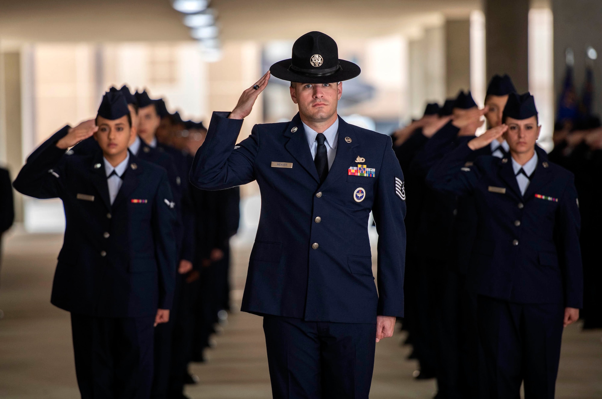 U.S. Air Force Tech. Sgt. Donald Weaver, 320th Training Squadron military training instructor, leads his flight with a salute during an Air Force BMT graduation Mar. 19, 2020, held at the 320th Training Squadron’s Airman Training Complex on Joint Base San Antonio-Lackland, Texas. Due to current world events, the 37th Training Wing has implemented social distancing by graduating 668 Airmen during four different ceremonies at different Airman Training Complexes. The graduation ceremonies will be closed to the public until further notice for the safety and security of the newly accessioned Airmen and their family members due to coronavirus (COVID-19).