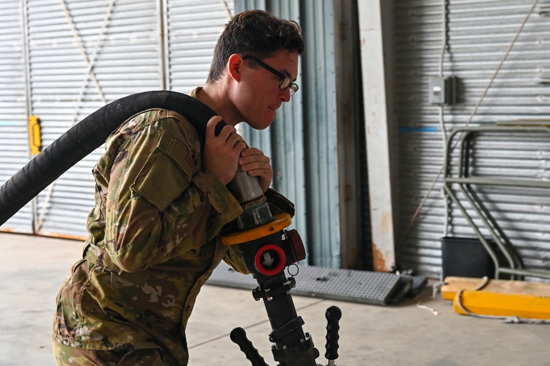 U.S. Air Force Senior Airman Cody Crumbling, 19th Logistics Readiness Squadron fuels operator, prepares to pump fuel into an Aerial Bulk Fuel Delivery System at Alpena Combat Readiness Training Center, Michigan, May 19, 2021. The ABFDS ensures minimal time spent on the ground by expeditiously refueling fighters while keeping engines on. (U.S. Air Force photo by Senior Airman Aaron Irvin)