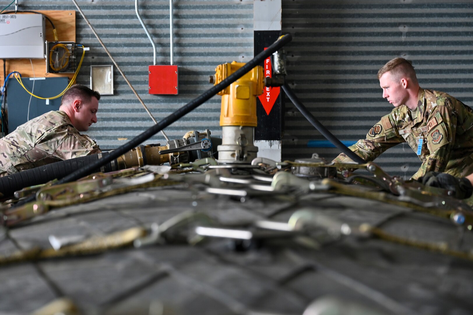 U.S. Air Force Staff Sgt. Garrett Huntoon, 374th Logistic Readiness Squadron fuels service center controller, left, and Airman 1st Class Griffin Nelson, 436th Logistics Readiness Squadron fuels operator, strap down an Aerial Bulk Fuel Delivery System at Alpena Combat Readiness Training Center, Michigan, May 19, 2021. The ABFDS, a portable 3,000-gallon fuel bladder, can be loaded on a C-130J Super Hercules, C-5 Galaxy, or C-17 Globemaster III and transported anywhere around the world. (U.S. Air Force photo by Senior Airman Aaron Irvin)