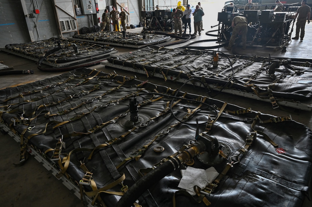 Airmen prepare to fill an Aerial Bulk Fuel Delivery System at Alpena Combat Readiness Training Center, Michigan, May 19, 2021. The ABFDS, a portable 3,000-gallon fuel bladder, can be loaded on a C-130J Super Hercules, C-5 Galaxy, or C-17 Globemaster III and transported anywhere around the world. (U.S. Air Force photo by Senior Airman Aaron Irvin)